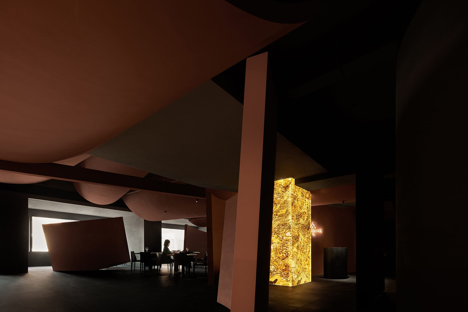 A modern restaurant interior showcasing sleek marble surfaces and polished concrete walls.