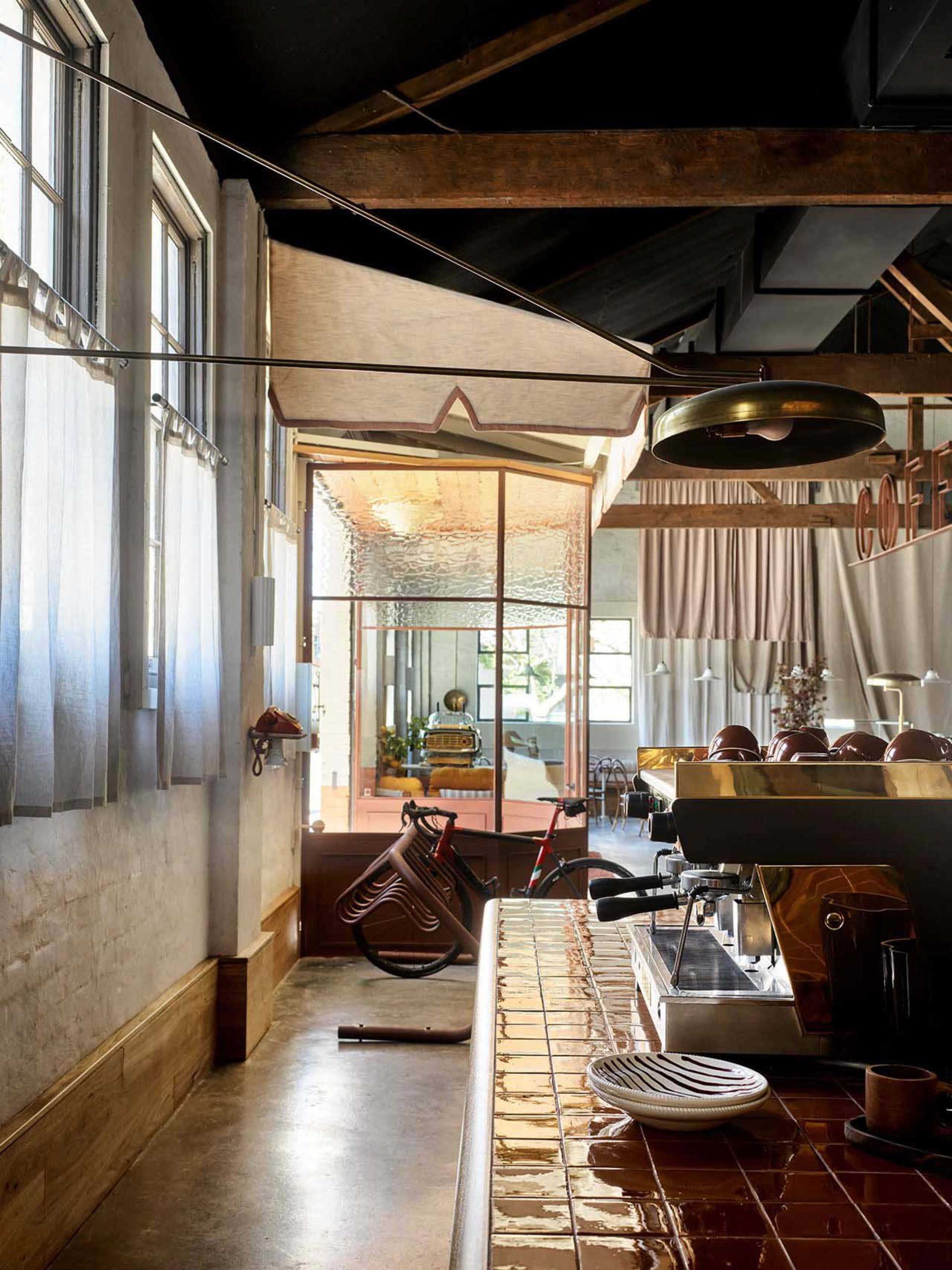 Modern industrial coffee shop bar with metal espresso machine and wooden counter