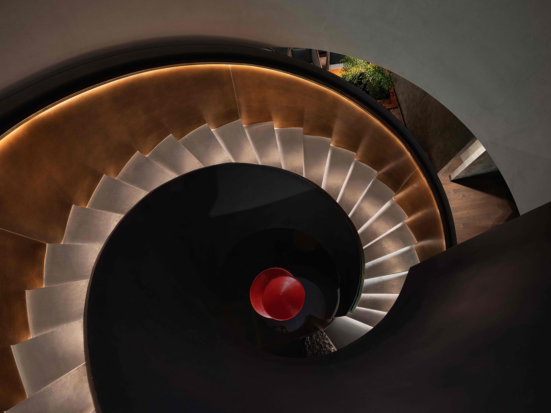 A sleek, modern, minimalist metal staircase with curved steps.
