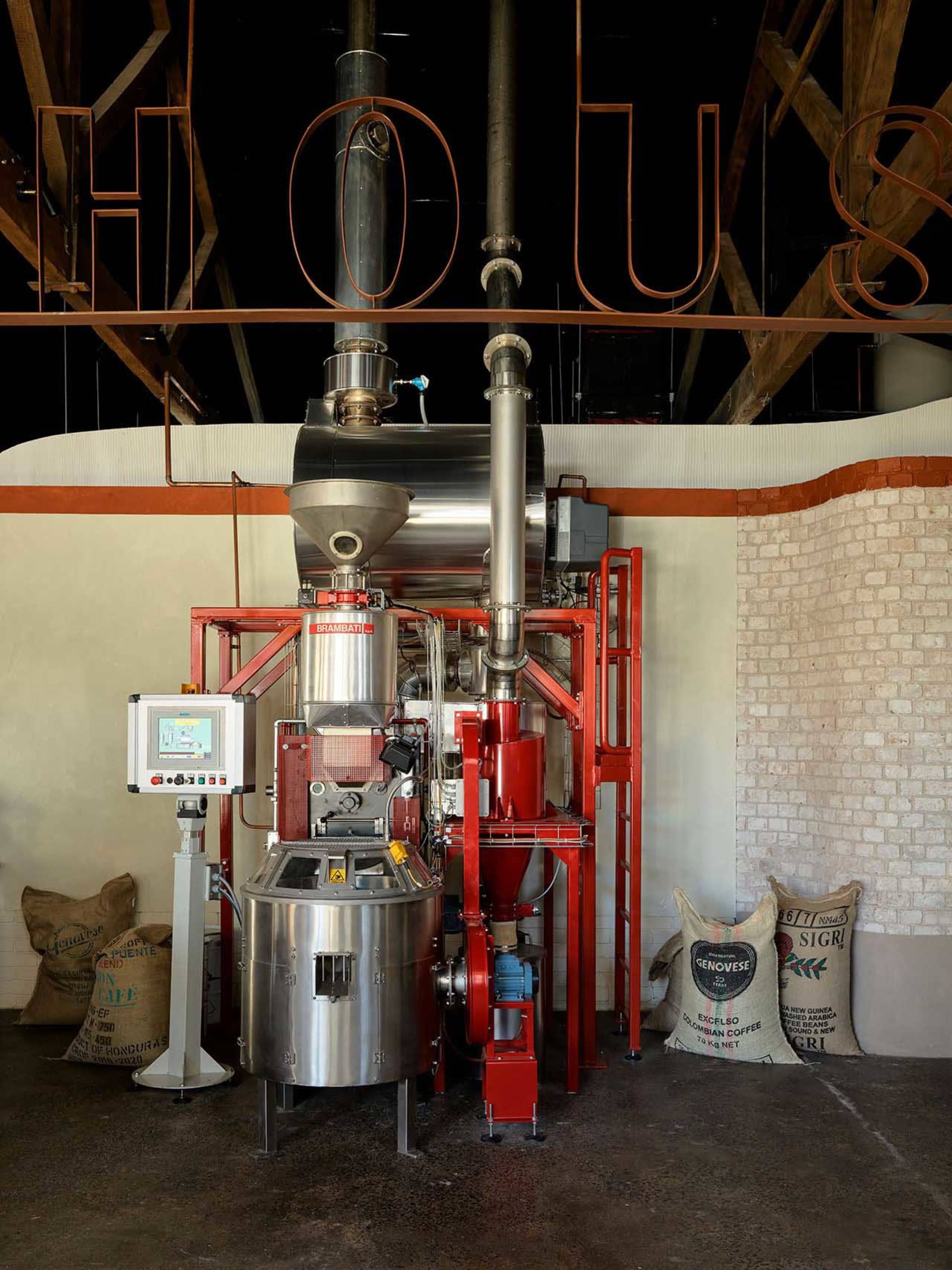 A large industrial coffee roasting machine with steel and brick materials.