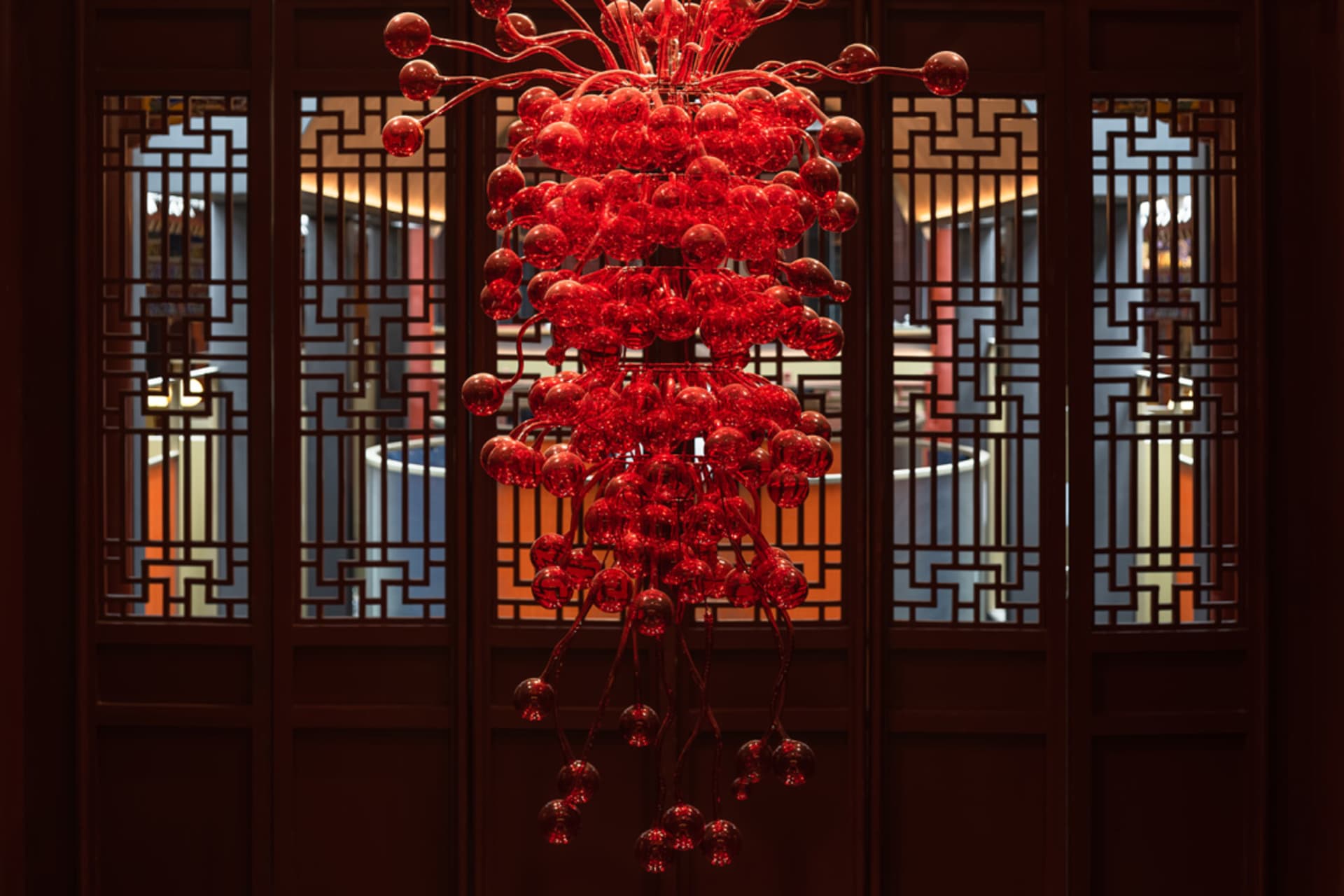 A red glass chandelier hanging in an interior space.