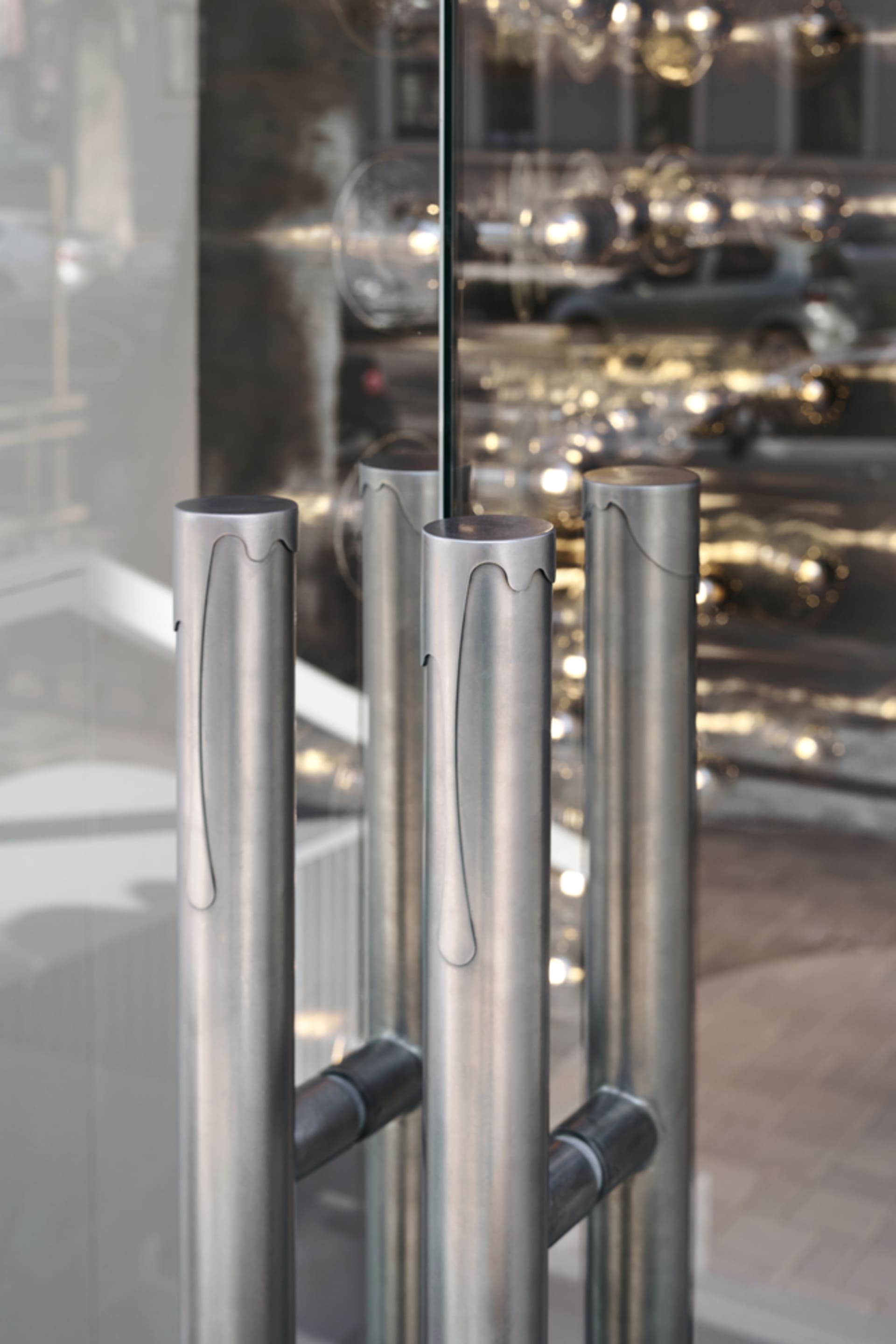 Close-up view of modern storefront entrance with vertical metal columns and glass panels.