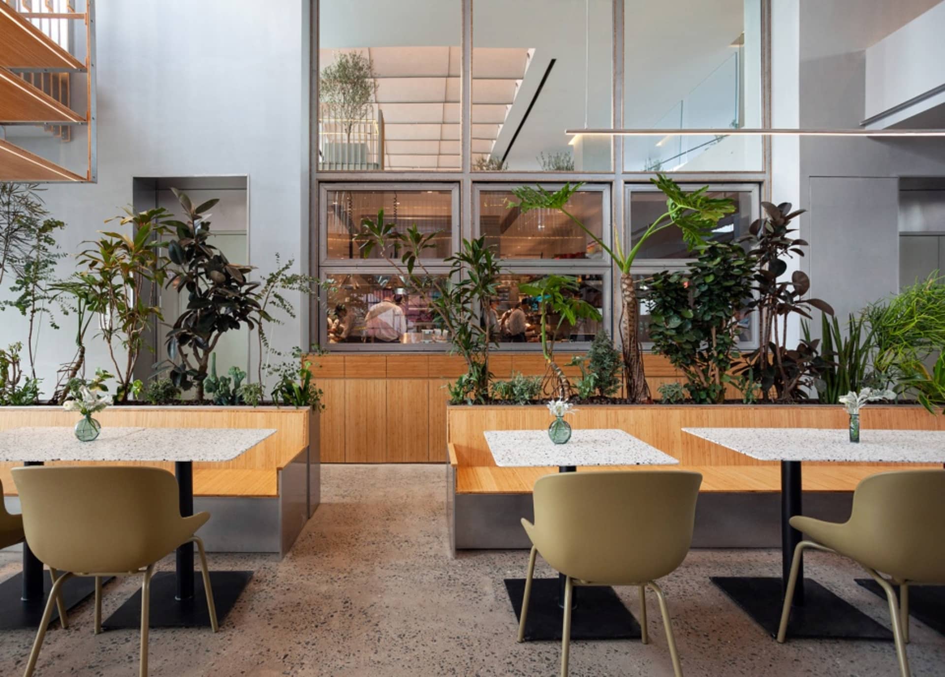 A modern cafe interior featuring wooden furniture and glass accents.