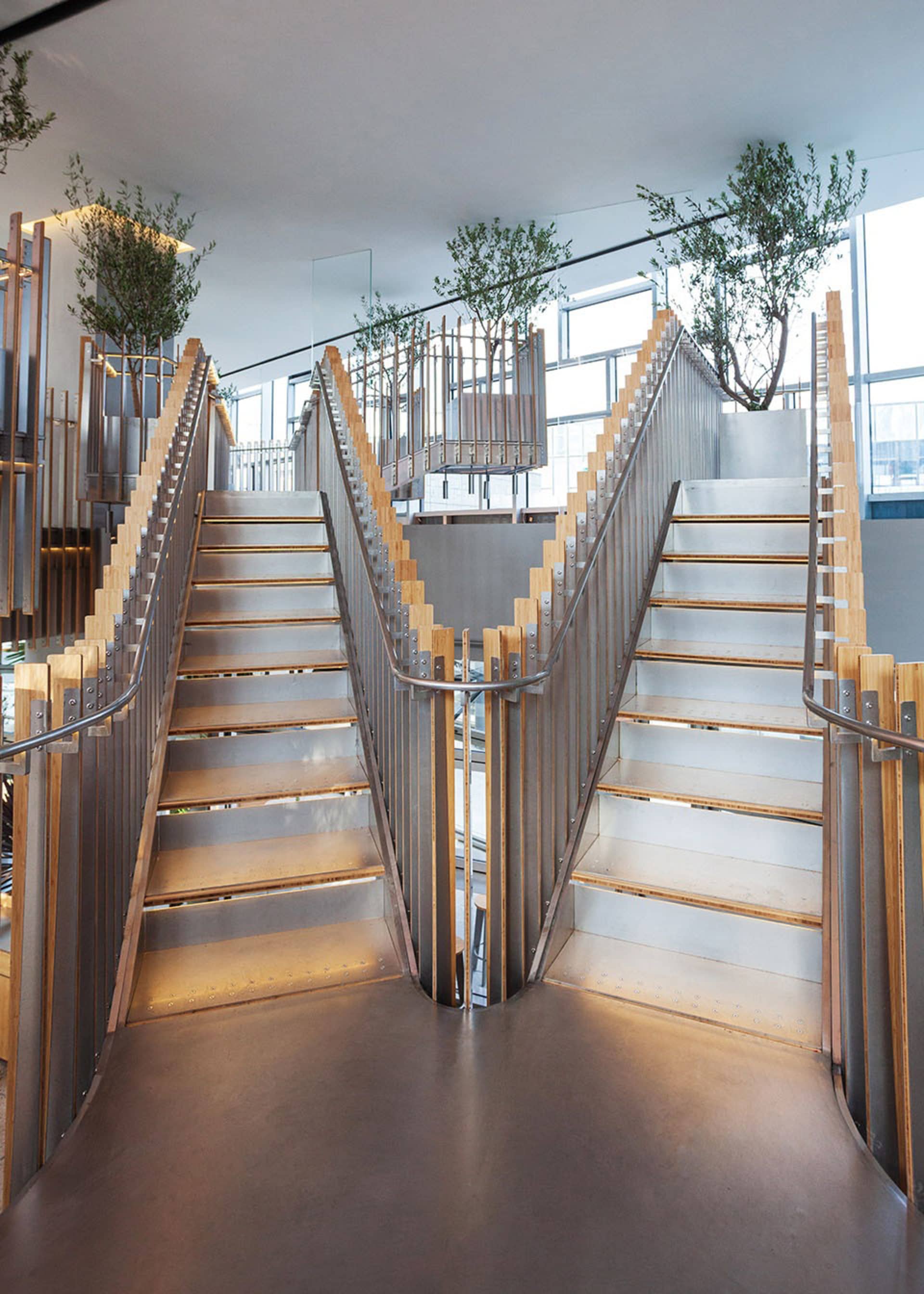 A modern industrial staircase made of metal and wood.