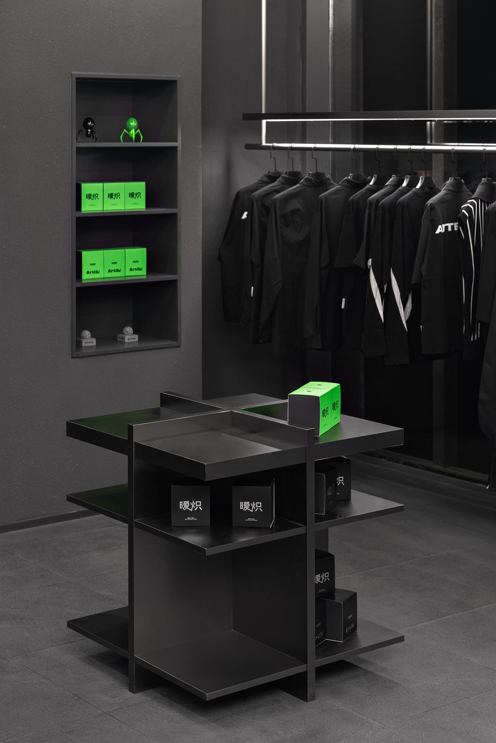 A modern retail storefront featuring black metal shelving units.