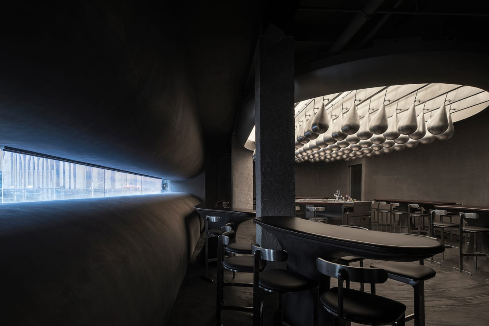 Industrial-style restaurant interior featuring metal stools and concrete walls and floor