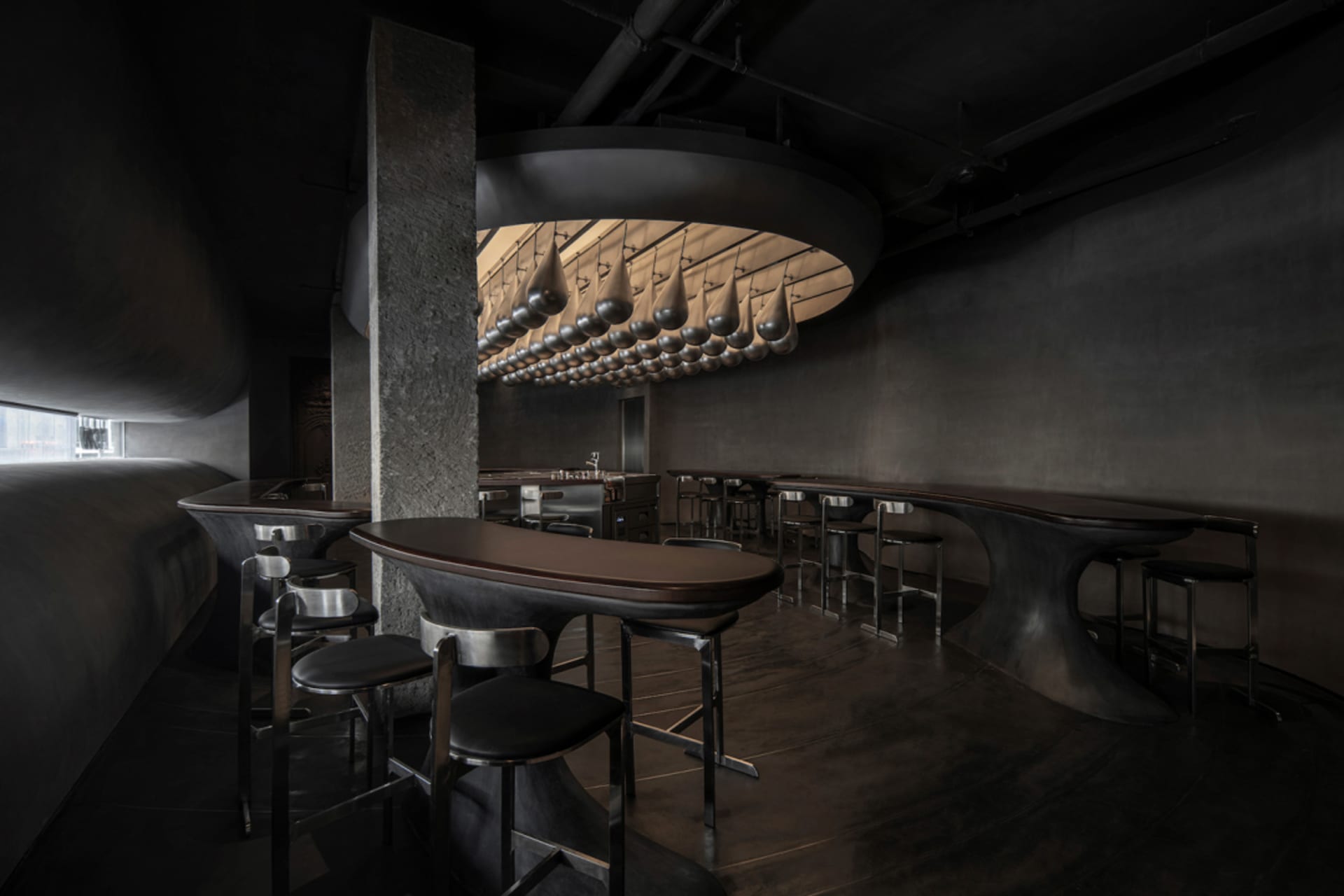 現代工業風餐廳內部,配有金屬吧台與高腳椅