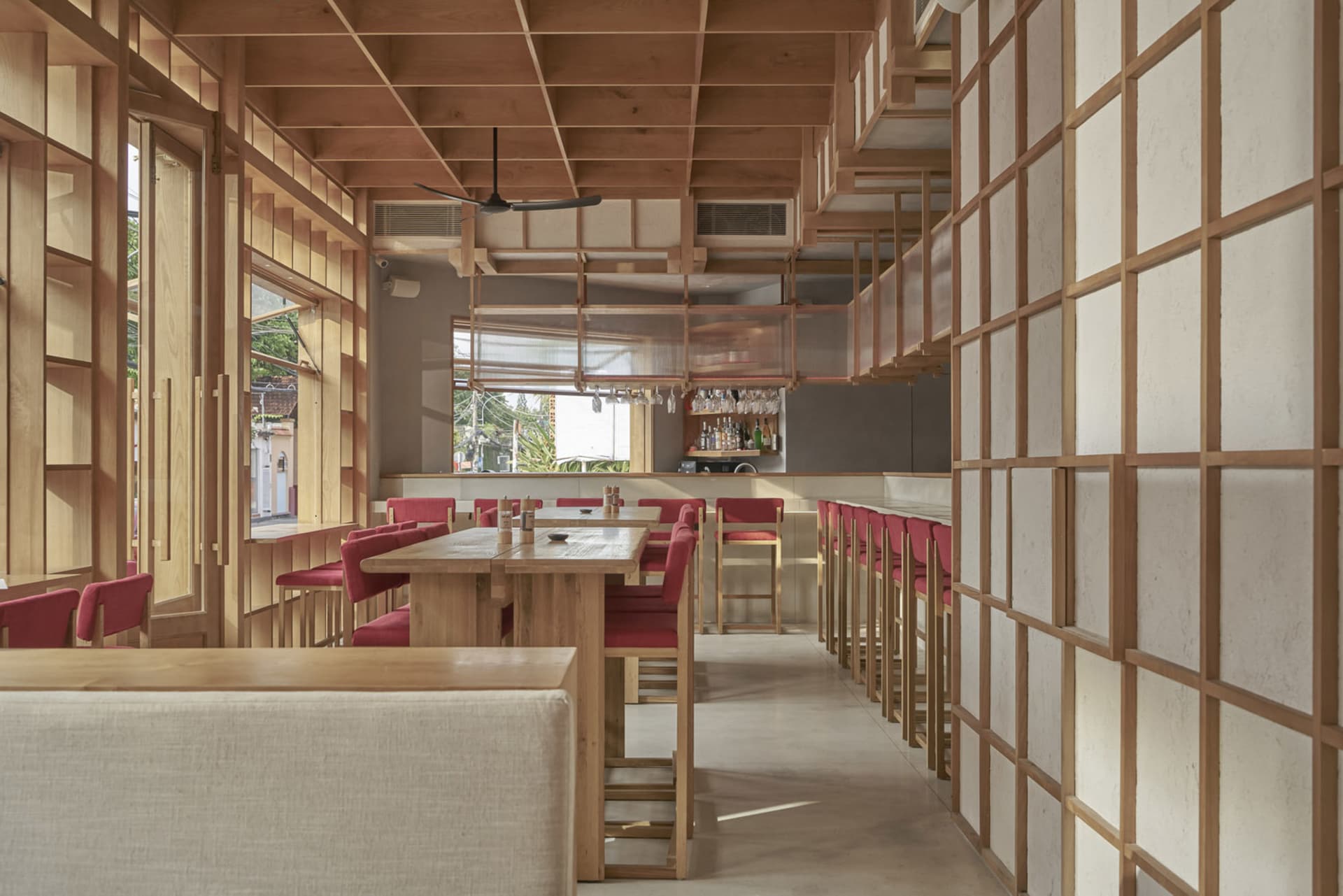 A modern restaurant interior with wooden tables and white walls.
