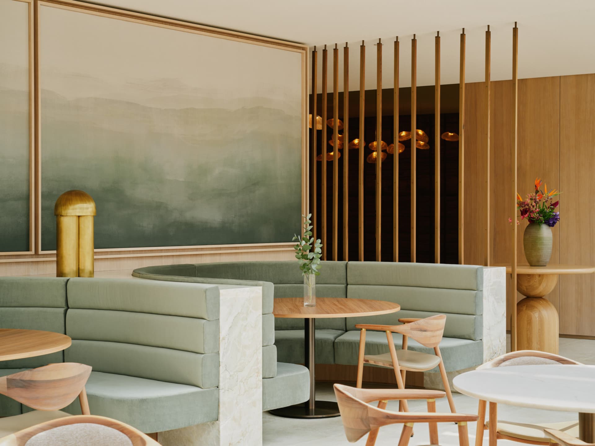 A modern restaurant interior with booth seating upholstered in suede and accented with marble and wood.