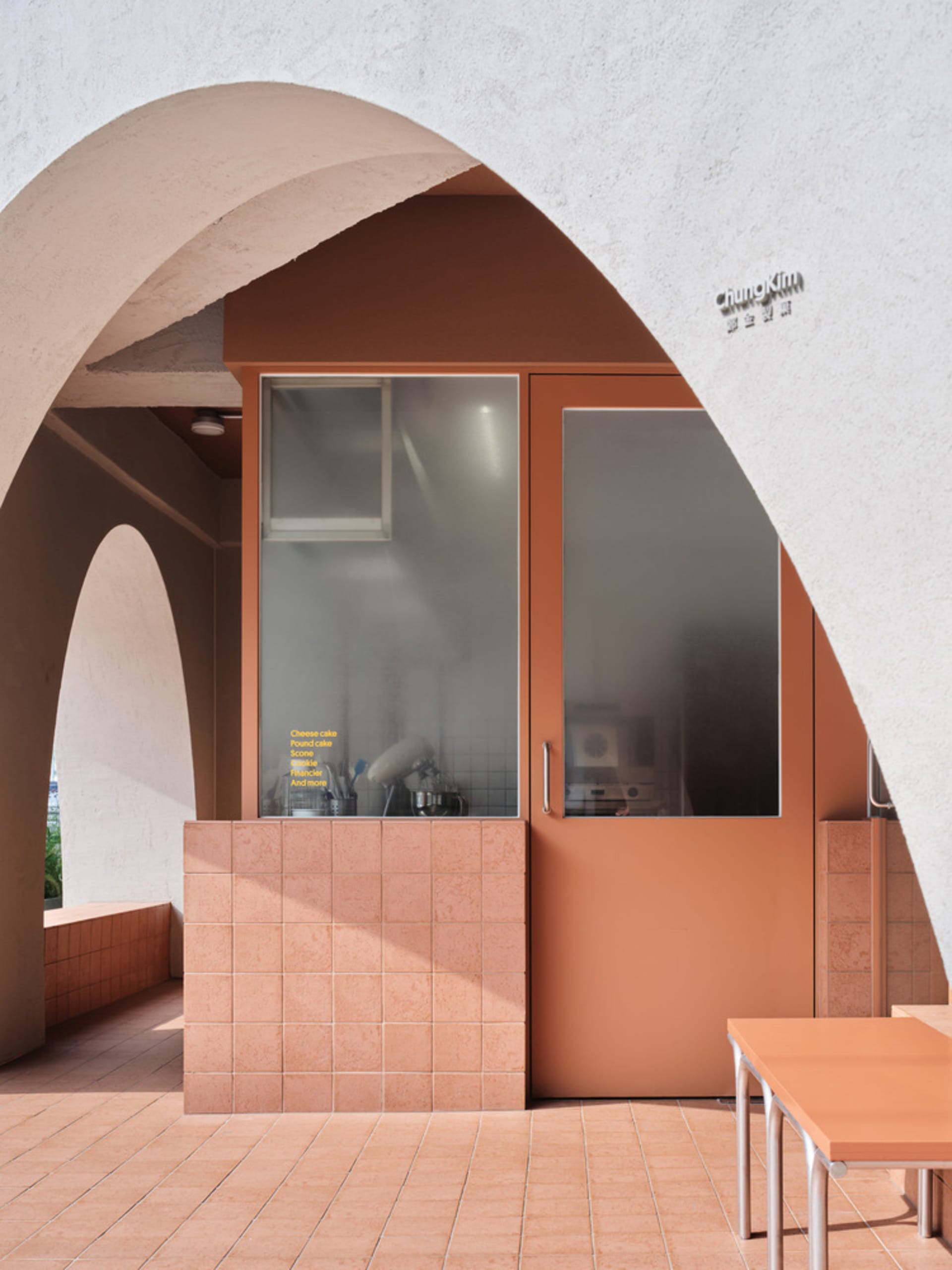 Modern cafe interior with clay tiles and concrete materials.