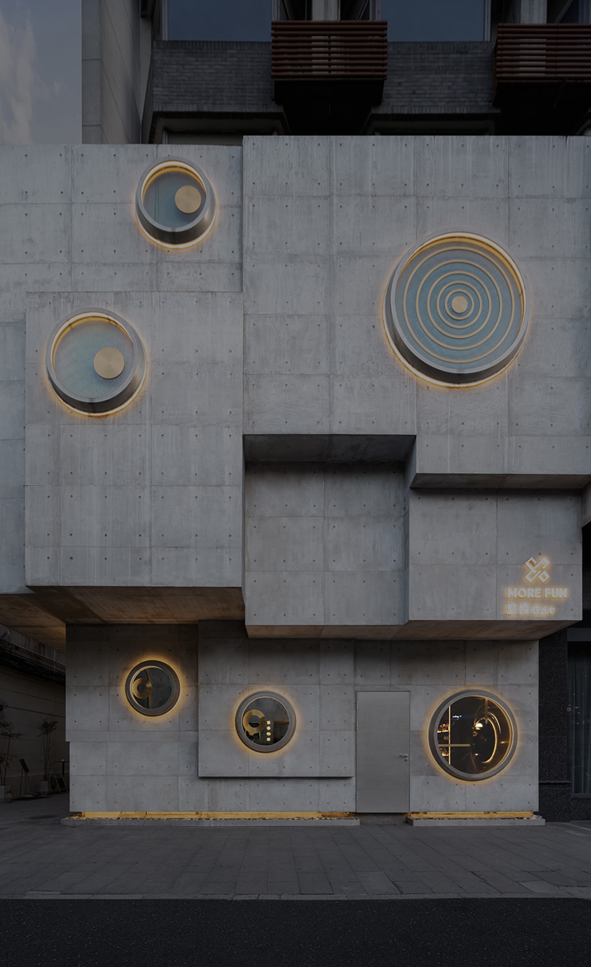 現代混凝土建築立面，圓形窗戶散發溫暖燈光。