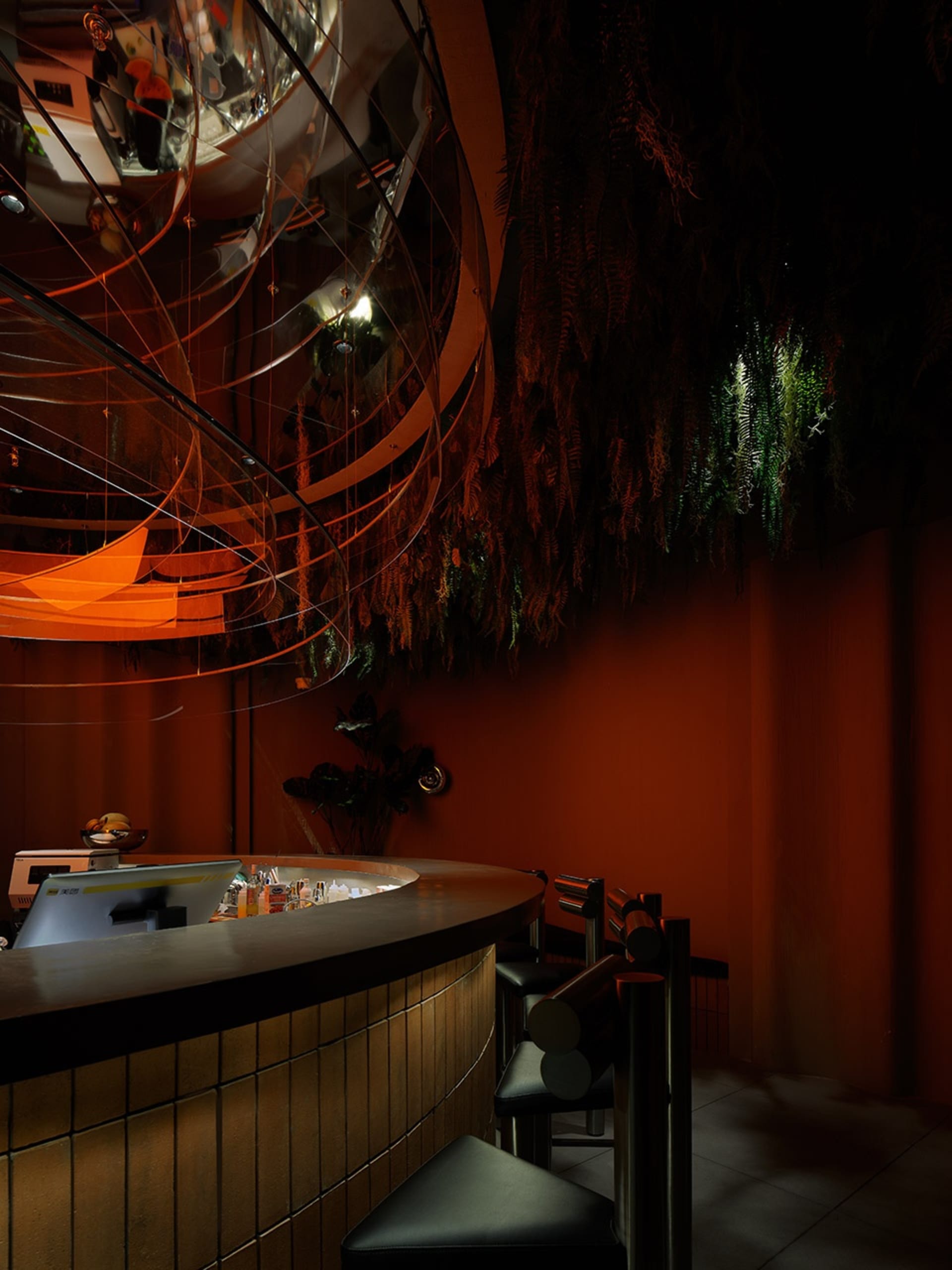 A modern bar interior with metallic spiral lights and industrial lighting fixtures.