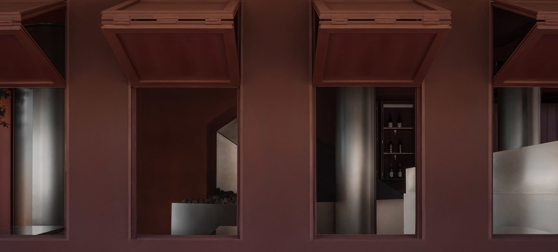 A modern wine cellar with metallic shelving units against a brick wall.