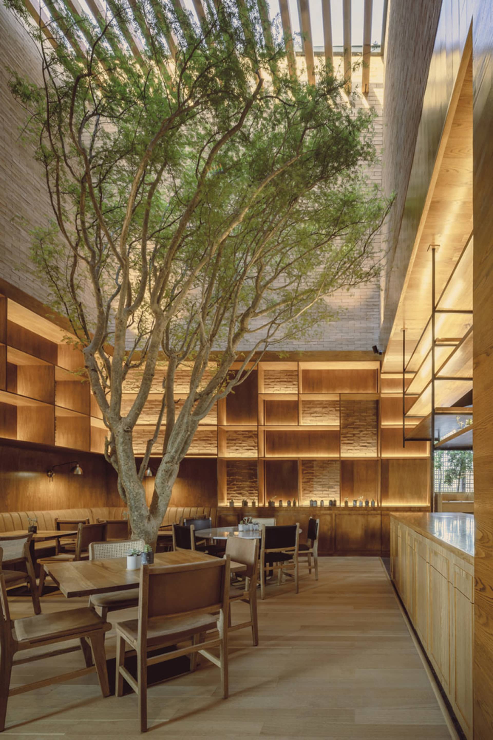 A modern restaurant interior with wood furniture and shelving.