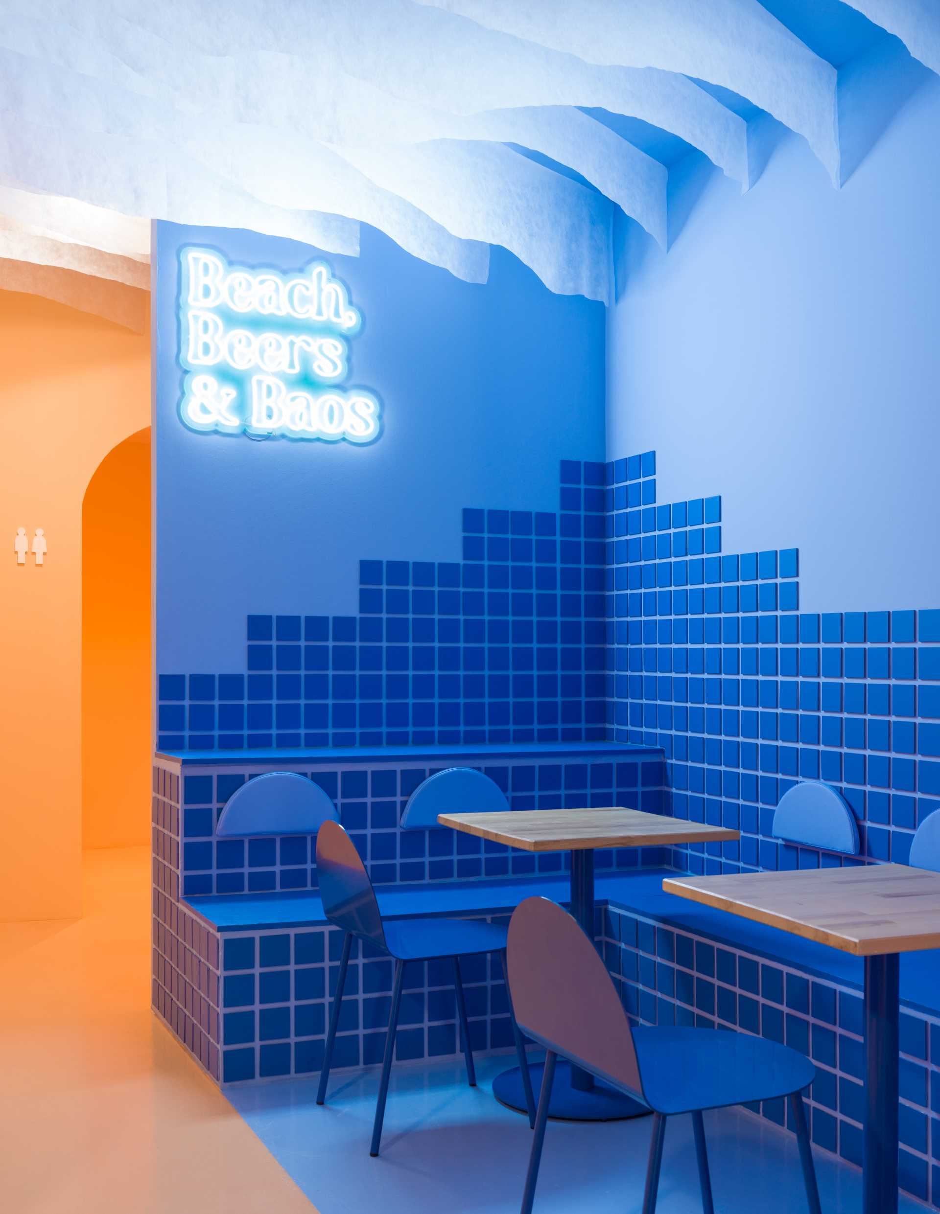 Modern restaurant interior with blue tiled walls and seating