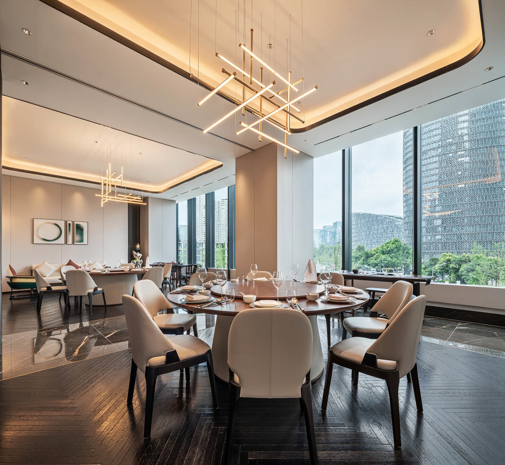 A modern minimalist dining room featuring luxury materials with a large round table and white chairs.
