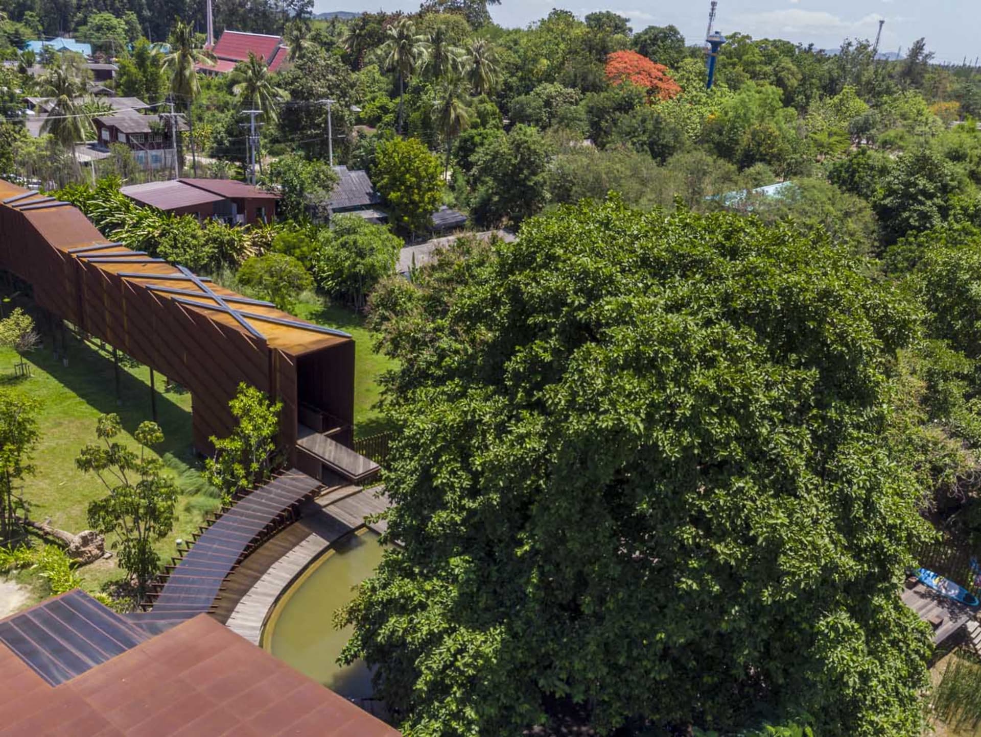 A modern metal bridge surrounded by lush greenery.