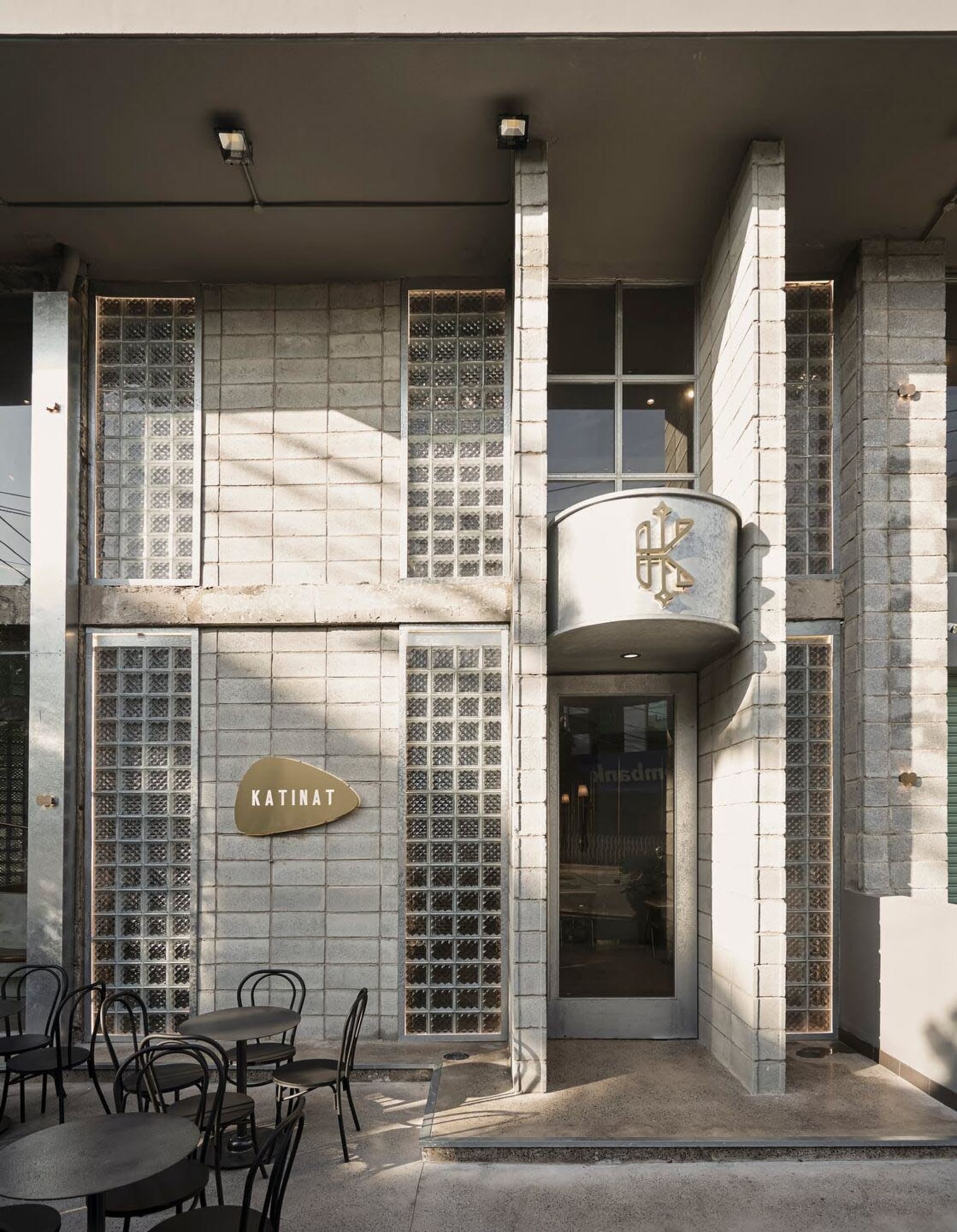Concrete and glass exterior of a modern restaurant with a logo that reads "KATINAT"