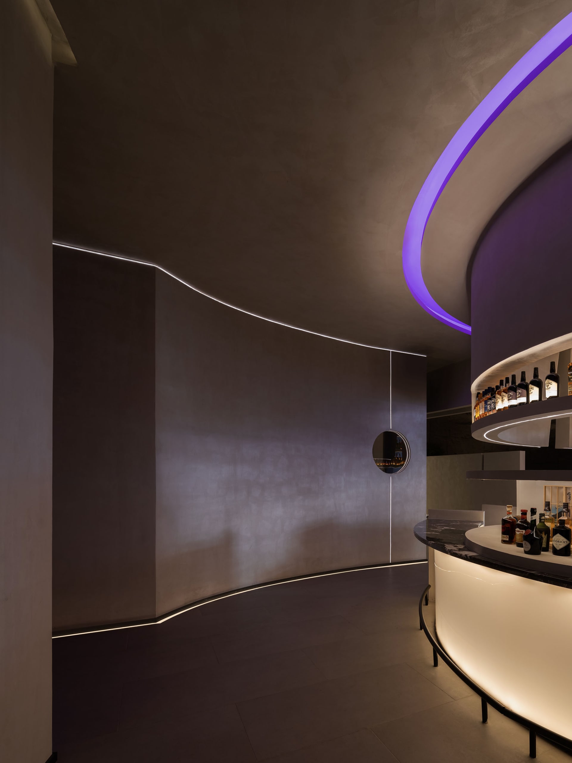 A modern bar with concrete walls illuminated by LED lighting