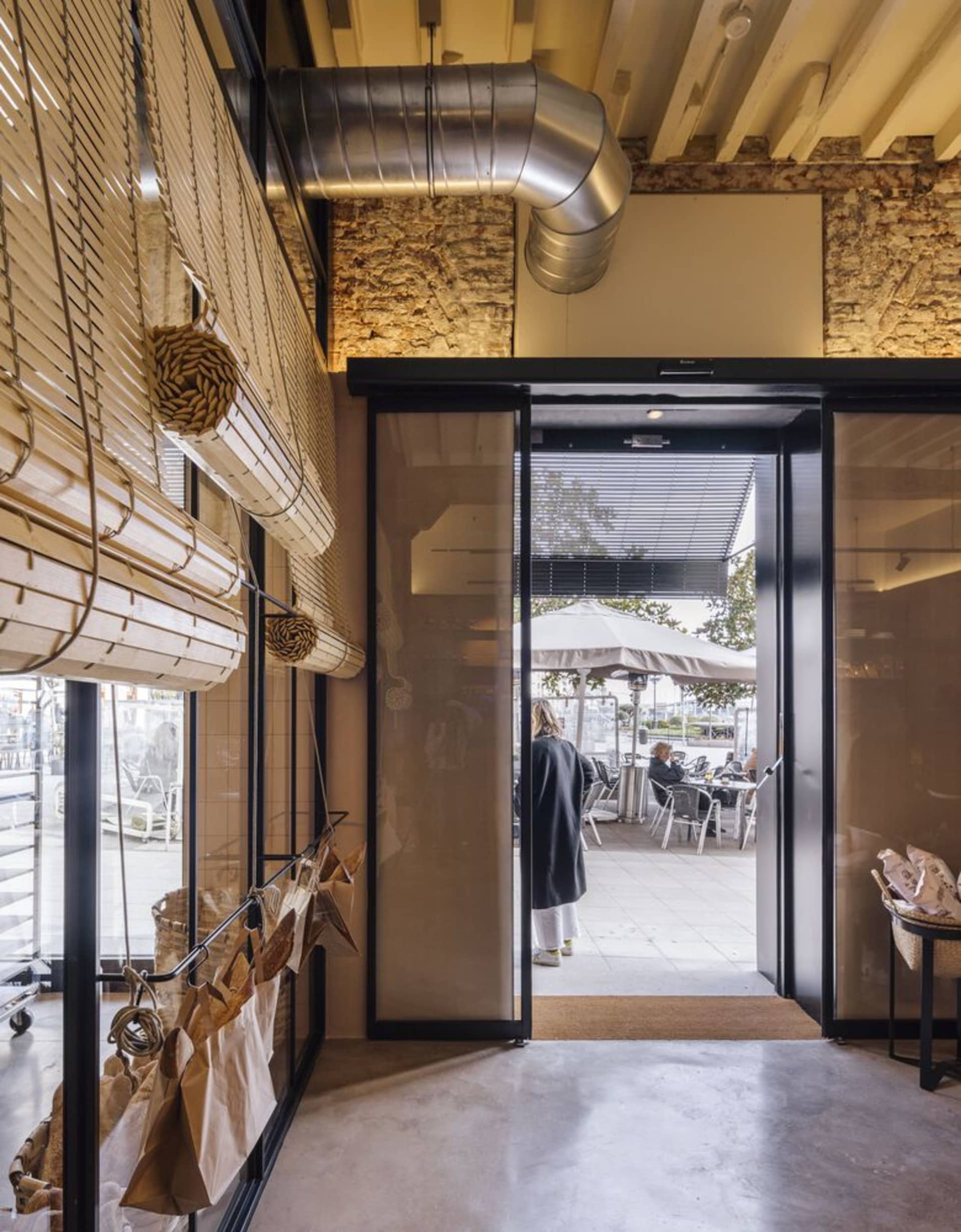 Industrial restaurant entrance with glass, concrete, and brick materials