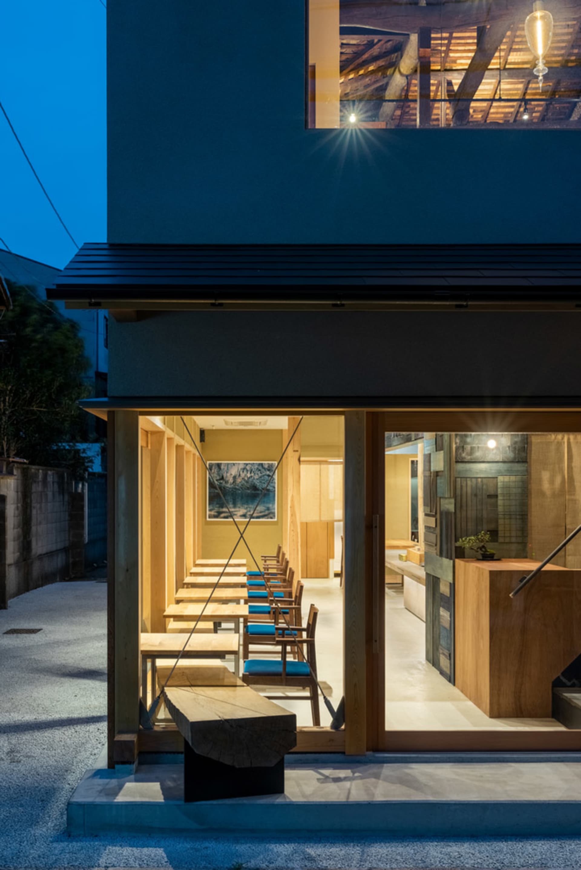 Modern restaurant interior with wooden tables and chairs.