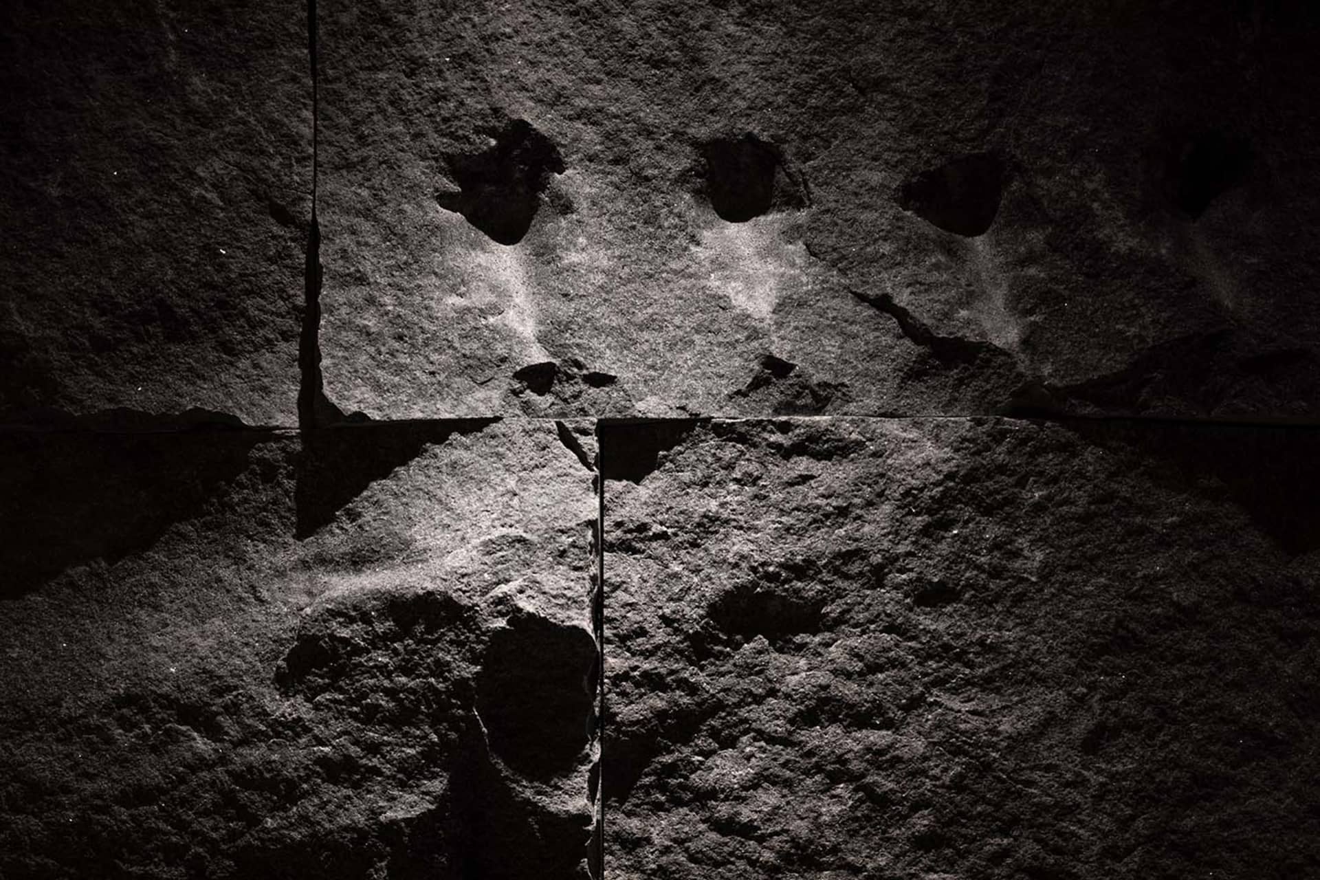 A textured stone wall covered with graffiti