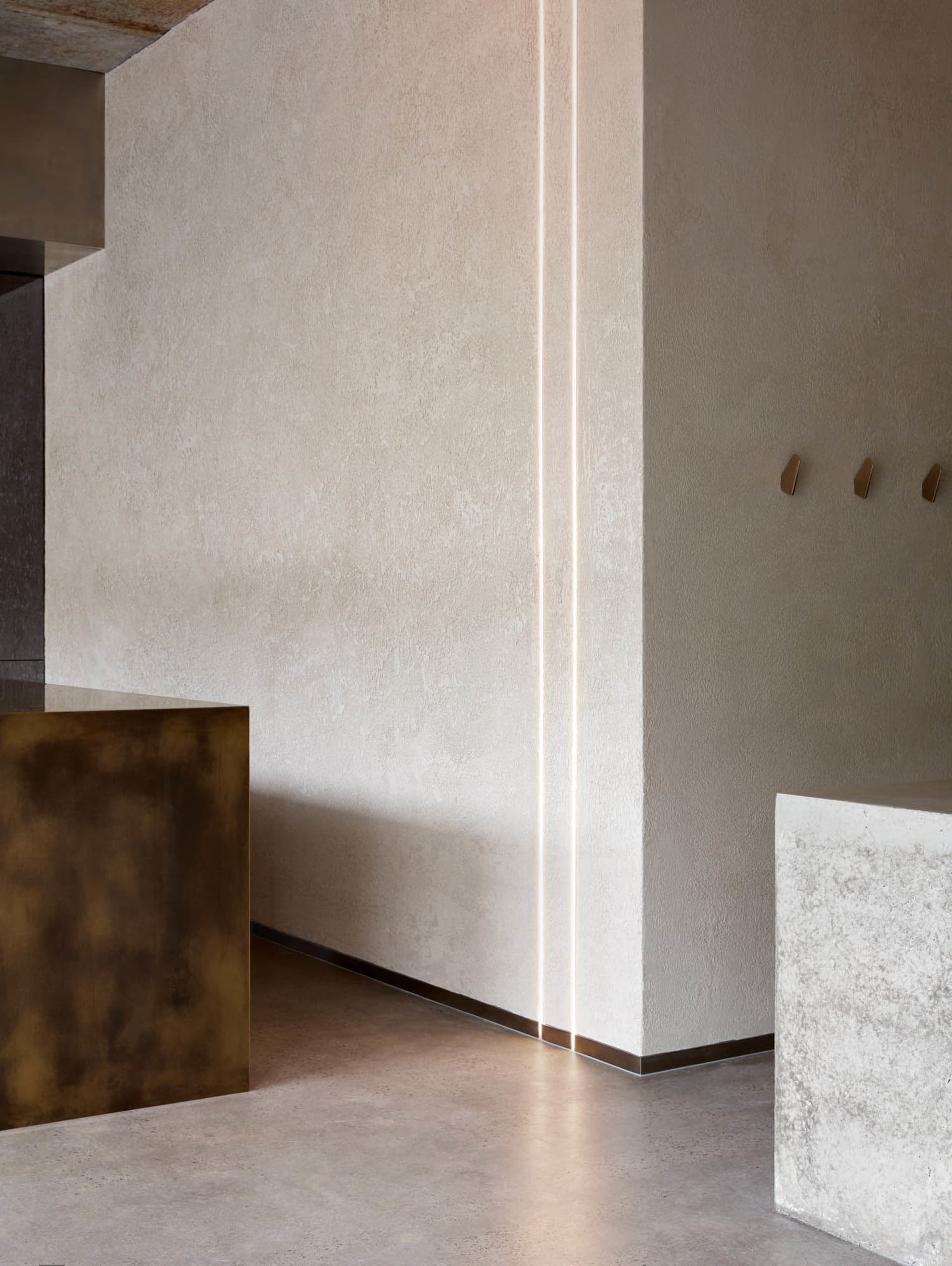 Modern interior design featuring concrete and brass elements.