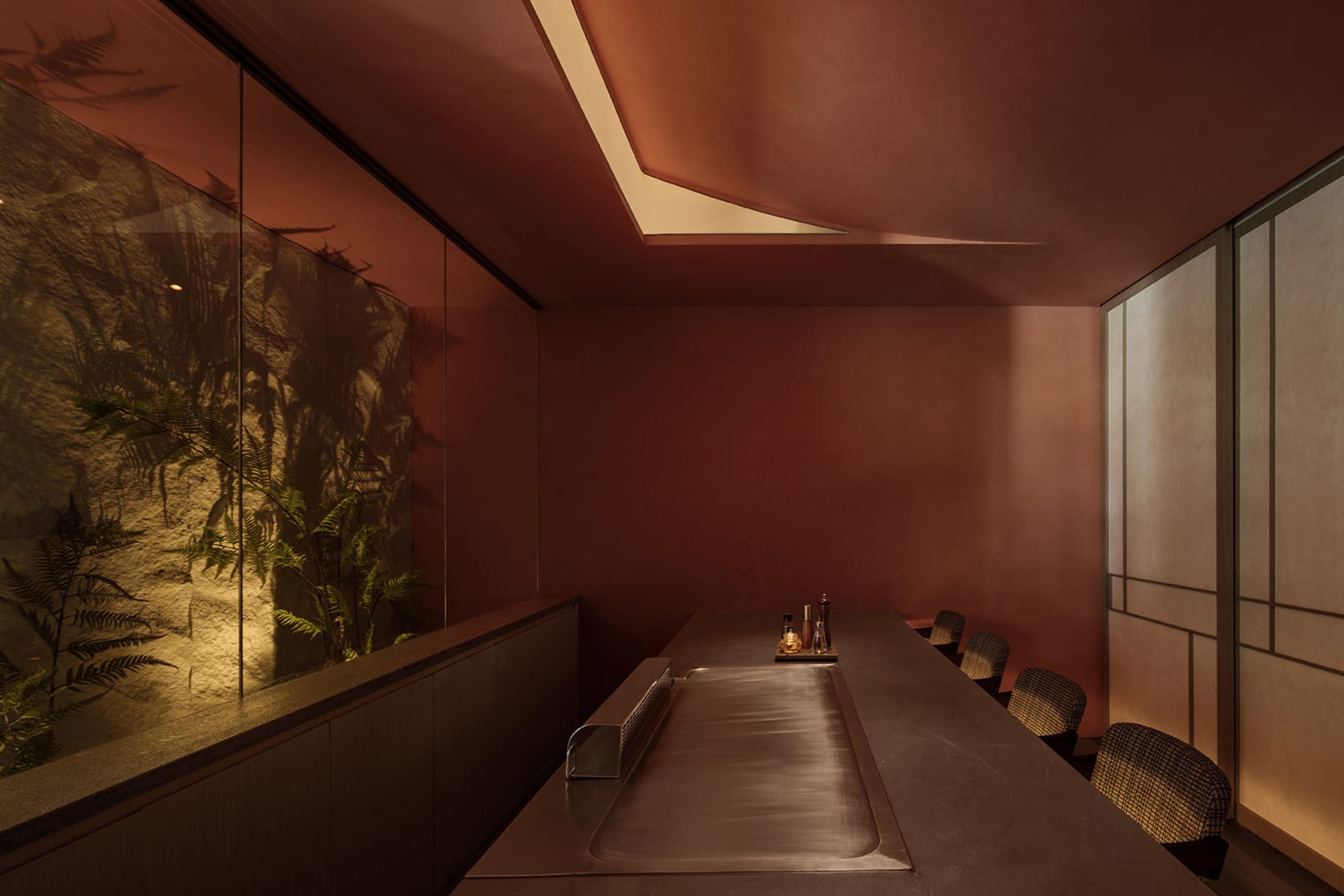 A minimalist restaurant interior featuring a brick counter and seating area.