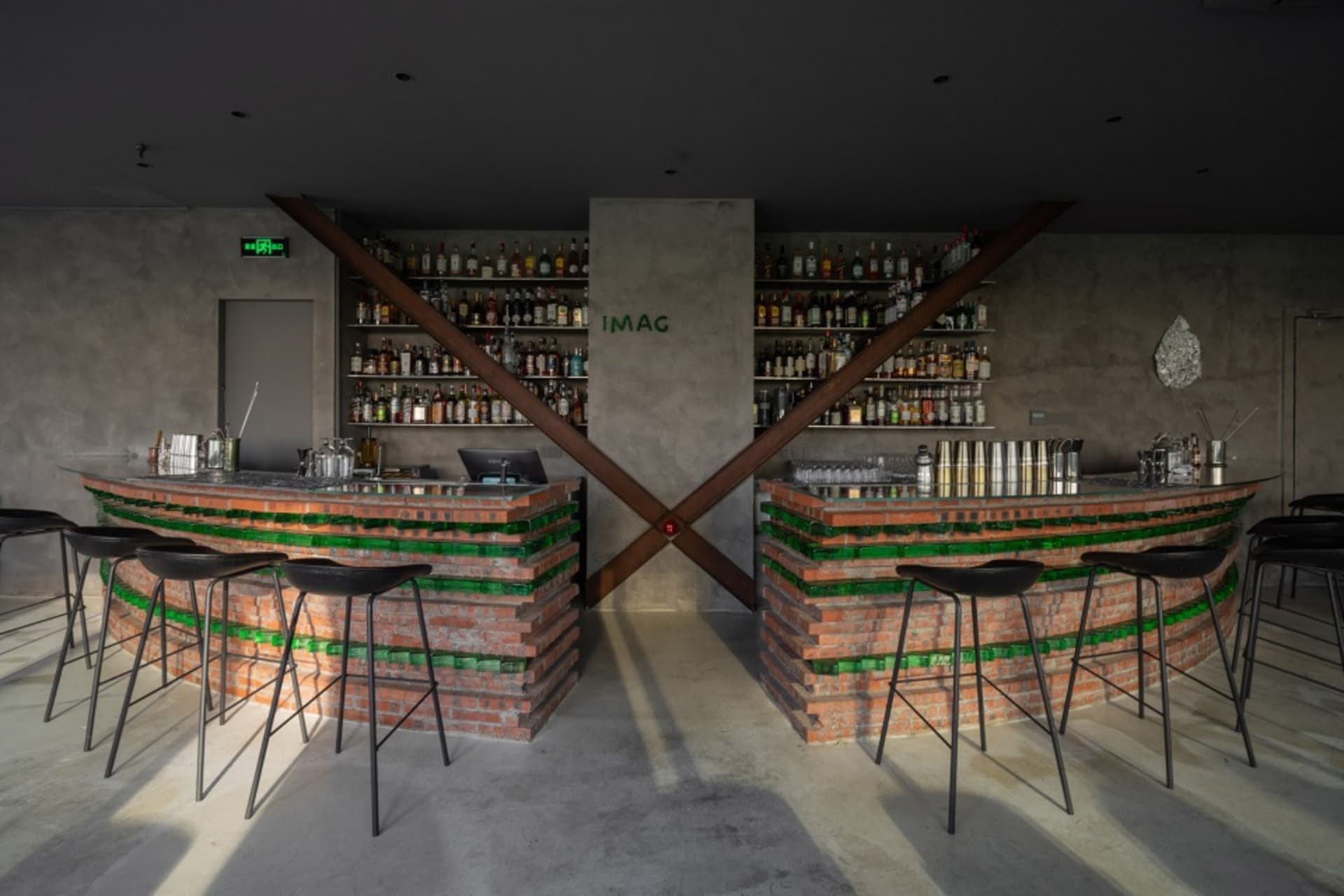 Industrial-style bar with brick walls, glass shelves, and metal bar stools.