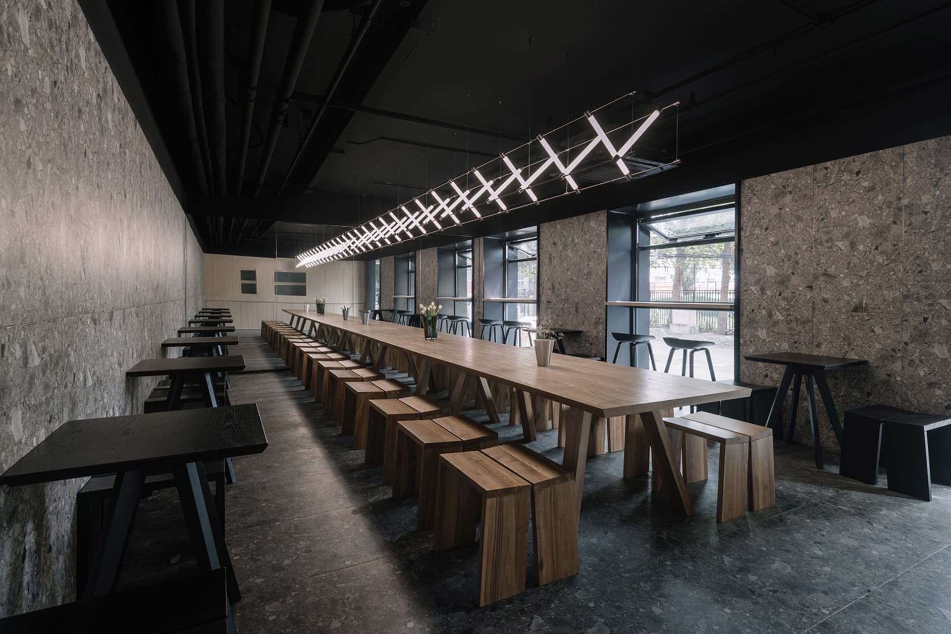Industrial-style cafe with wooden furniture and pendant lighting.