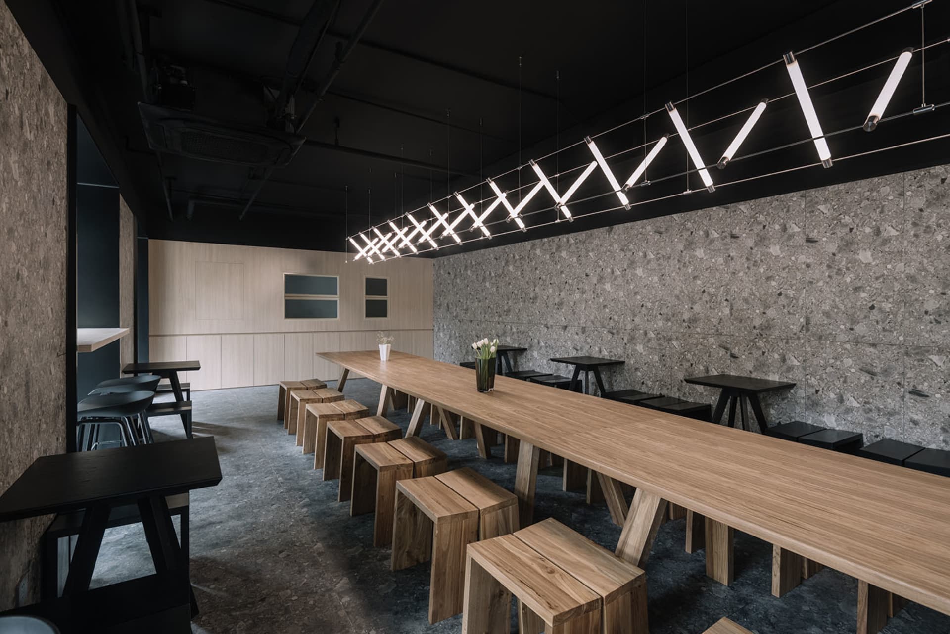 Modern industrial-style cafe interior with wooden tables and concrete walls