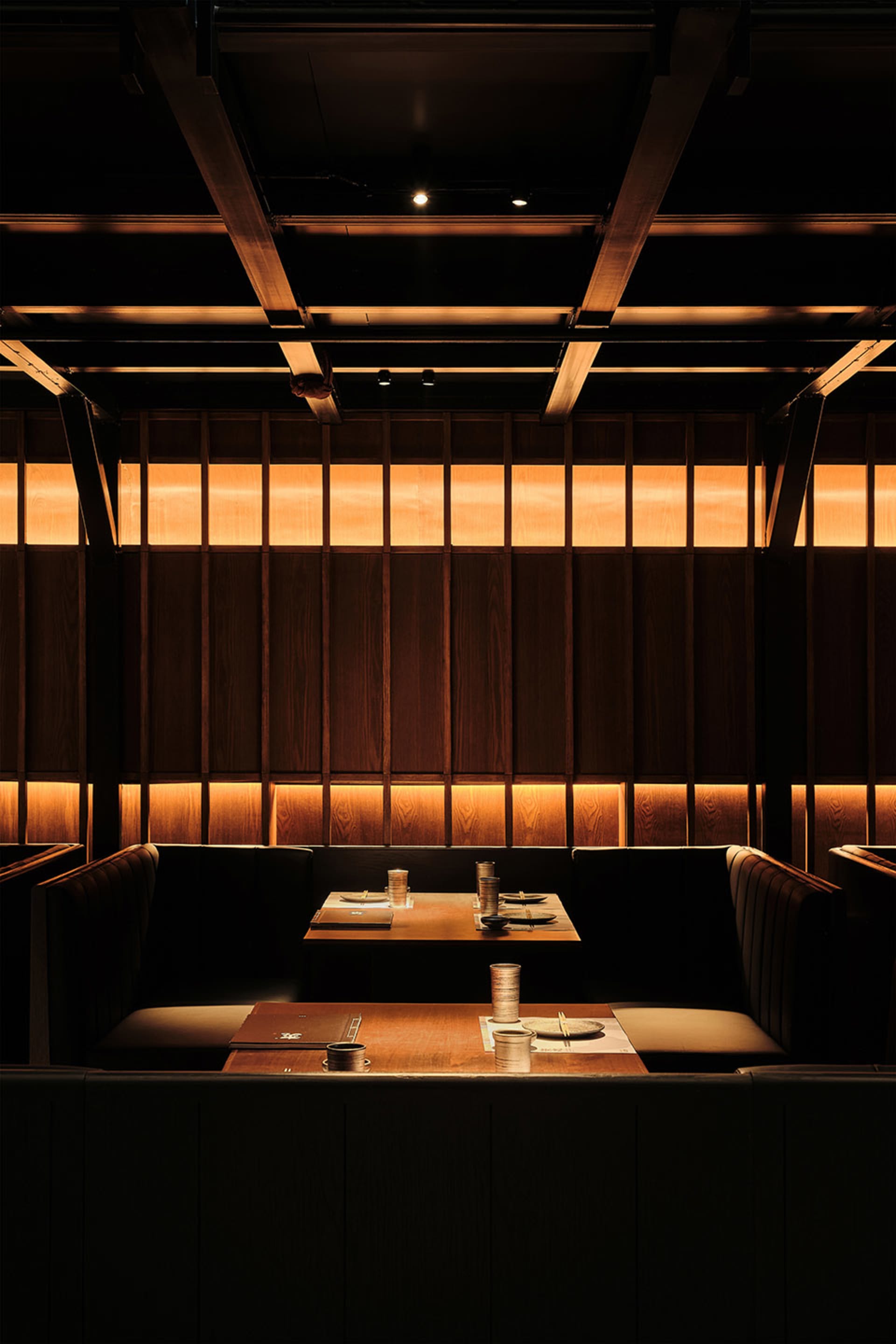 Industrial-themed restaurant interior with wooden banquettes and lighting