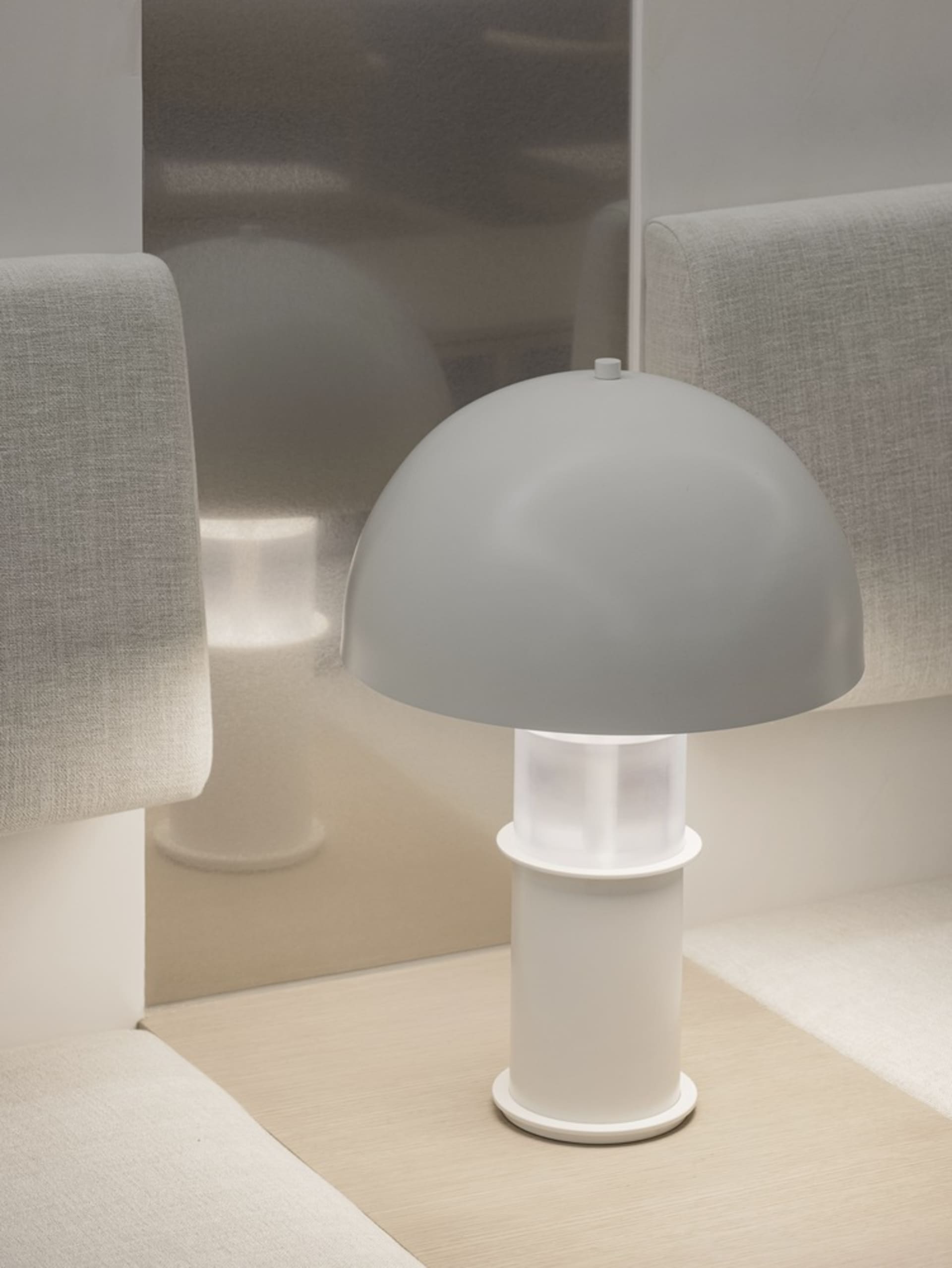 A minimalist table lamp with a white plastic base and lampshade
