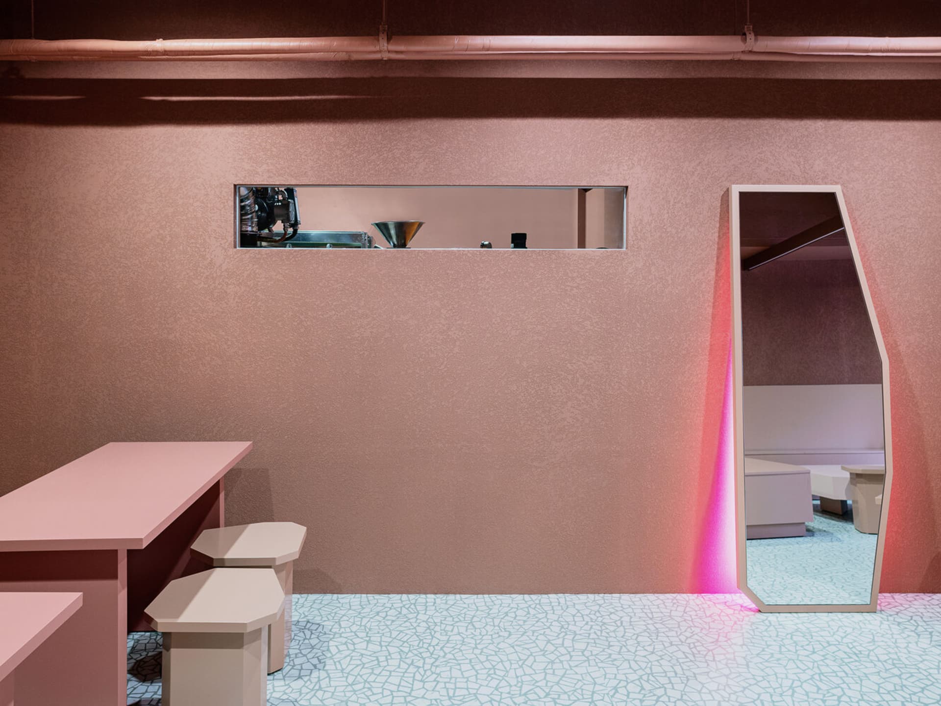 Modern cafe interior with terrazzo flooring and minimalist furniture.