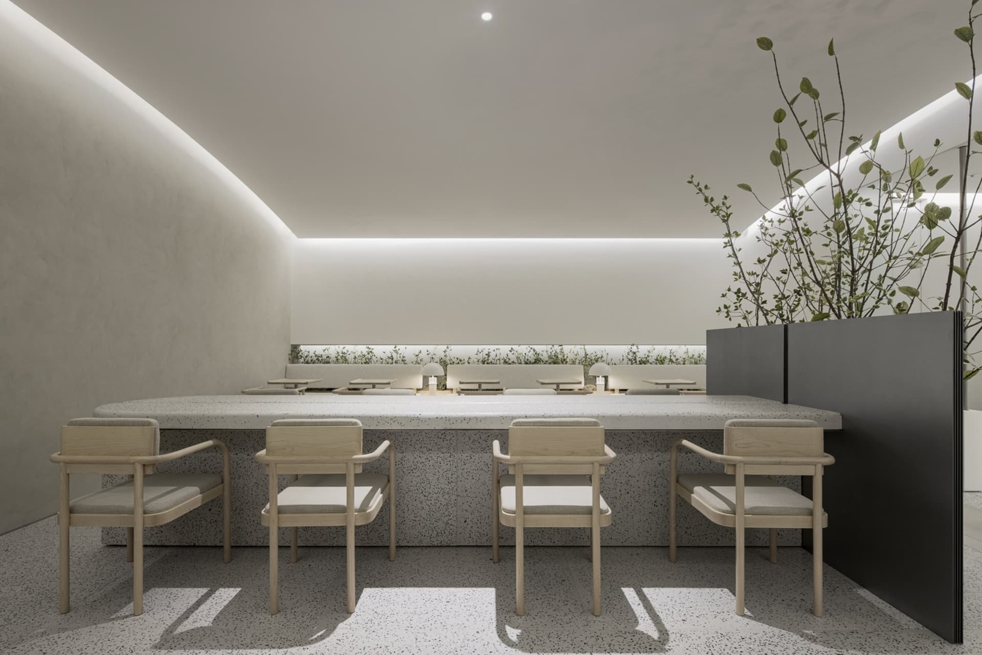A modern restaurant interior with concrete walls and floors, featuring minimalist furniture and a serene atmosphere.