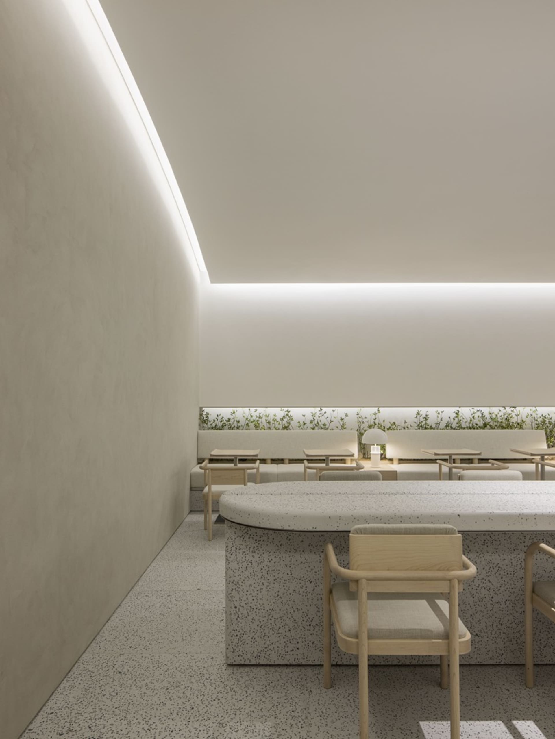 Contemporary restaurant interior featuring modern design elements such as terrazzo flooring and upholstered seating.