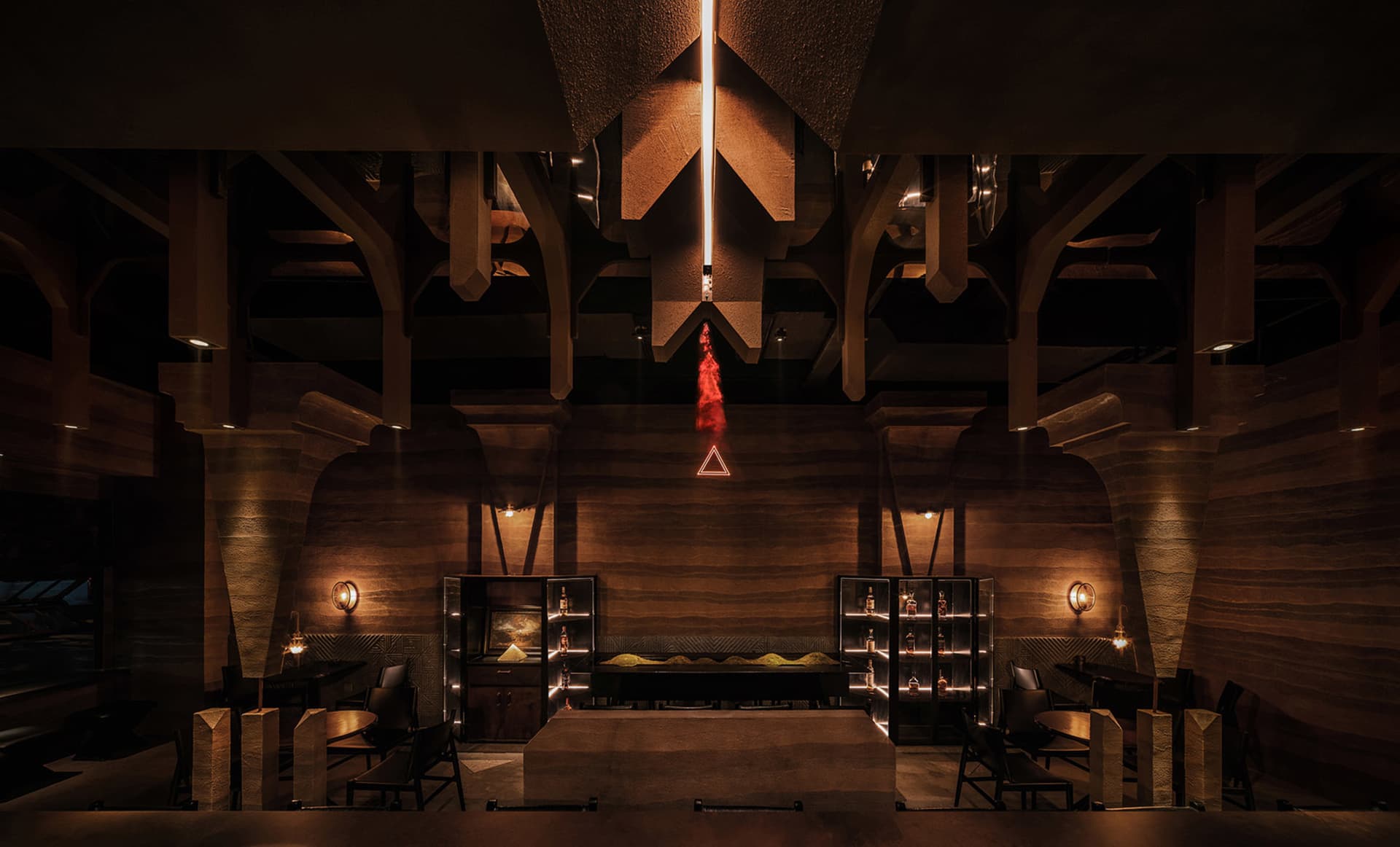 A modern industrial restaurant interior with concrete walls, high ceilings, and warm lighting.
