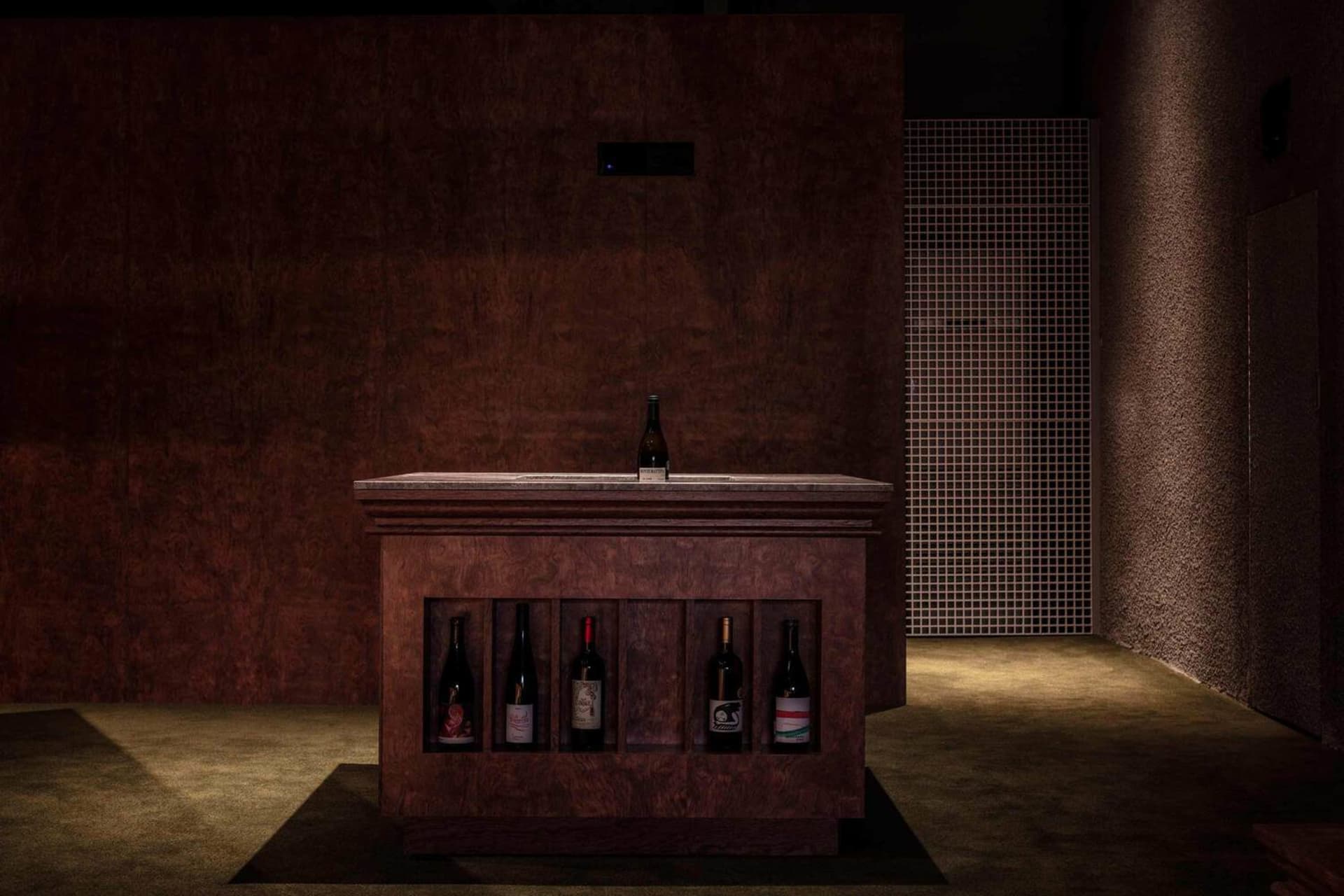 A modern wine bar with wooden shelves and bottles of wine.