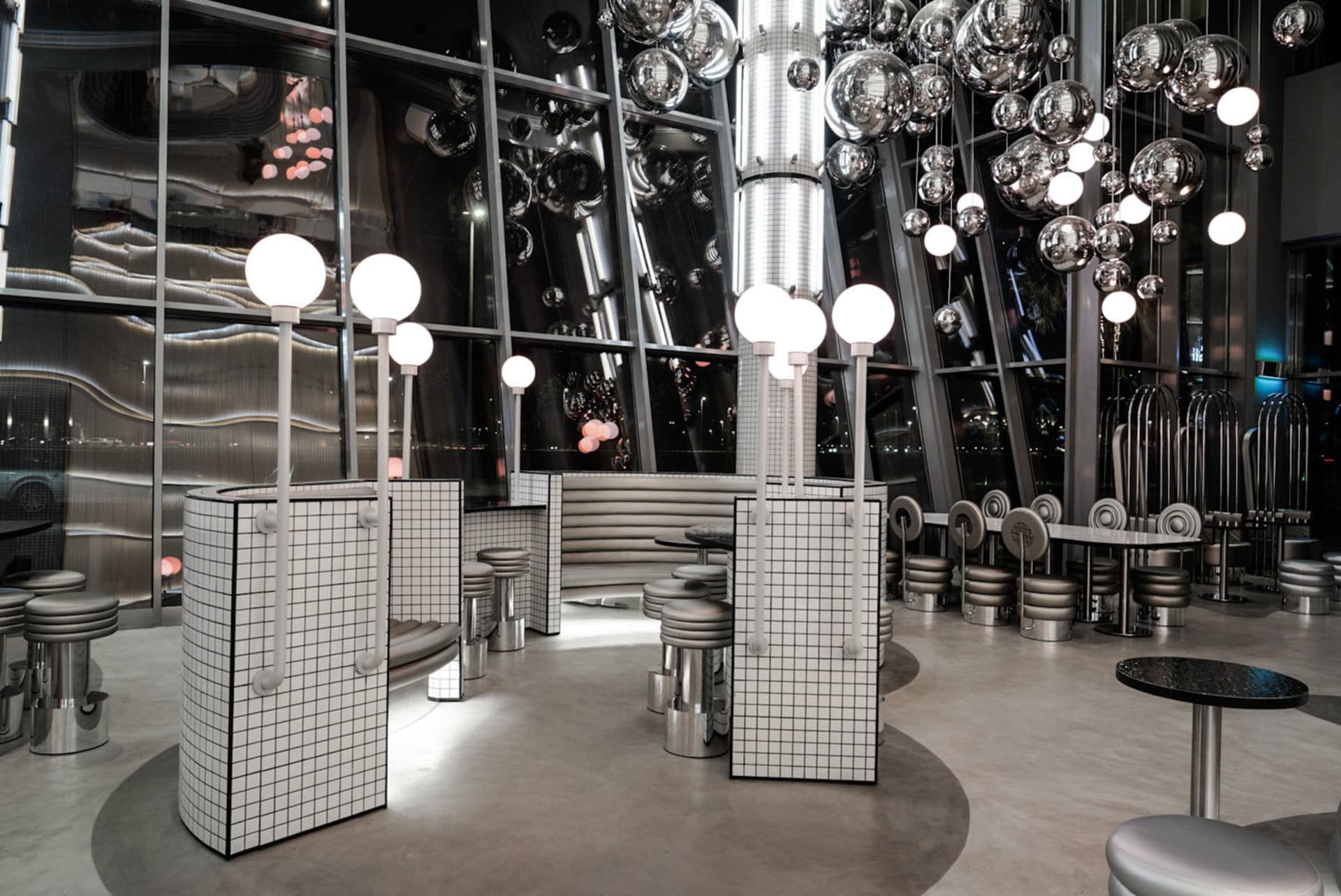 A modern restaurant interior with metallic elements and reflective surfaces.