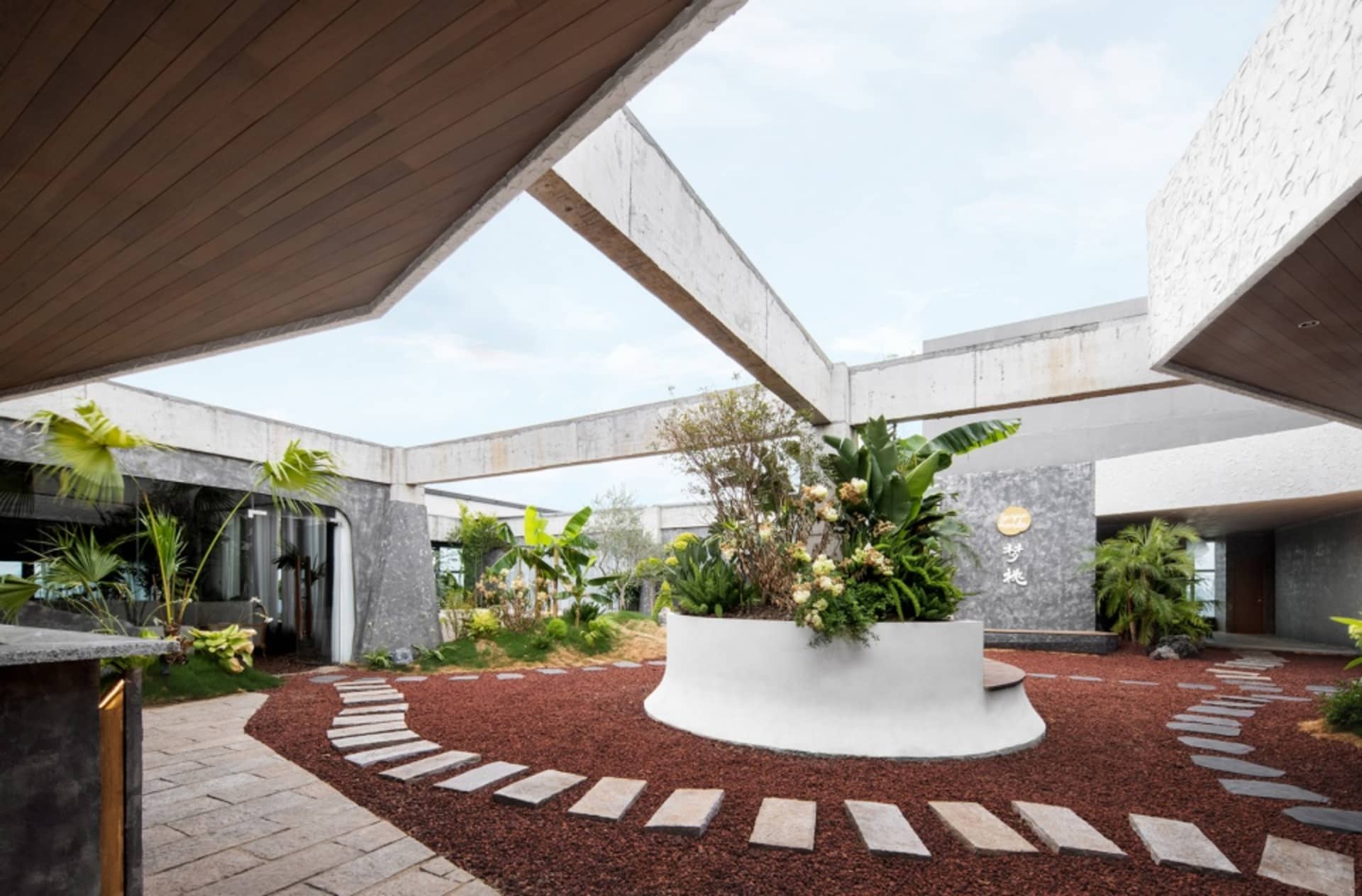 A modern interior space featuring a concrete garden with plants and flowers.
