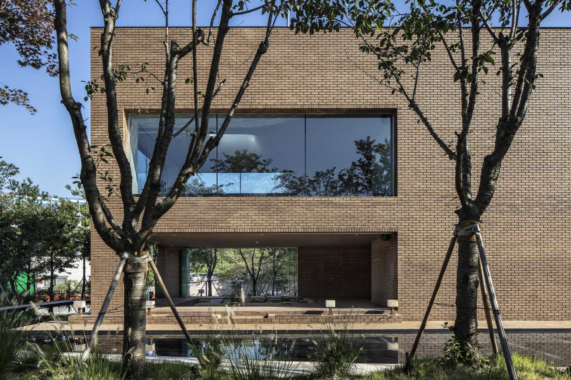 Modern house with brick exterior and large windows.