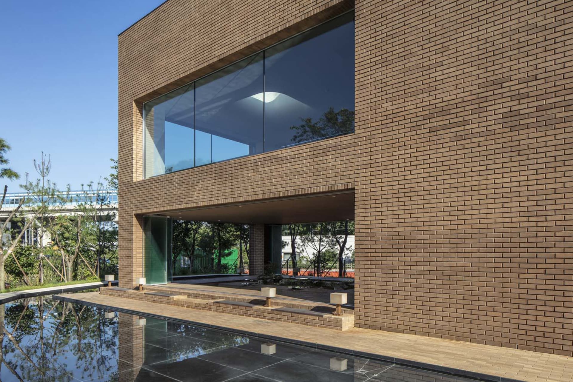 A modern residential exterior featuring a combination of brick and concrete materials.