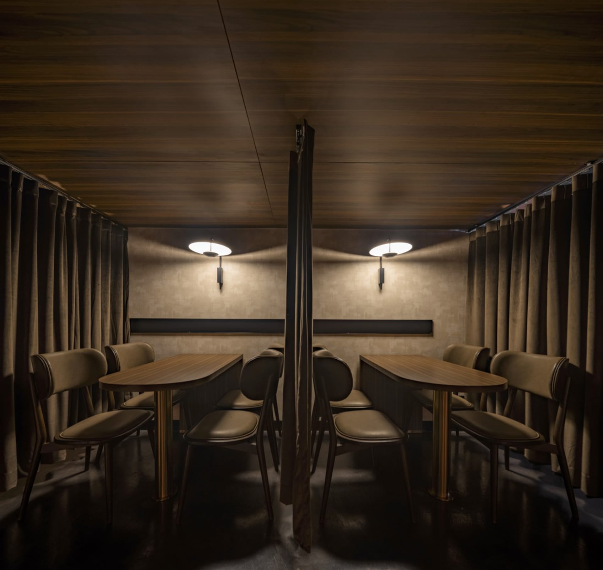 Restaurant interior with wooden walls, leather seating, and fabric curtains