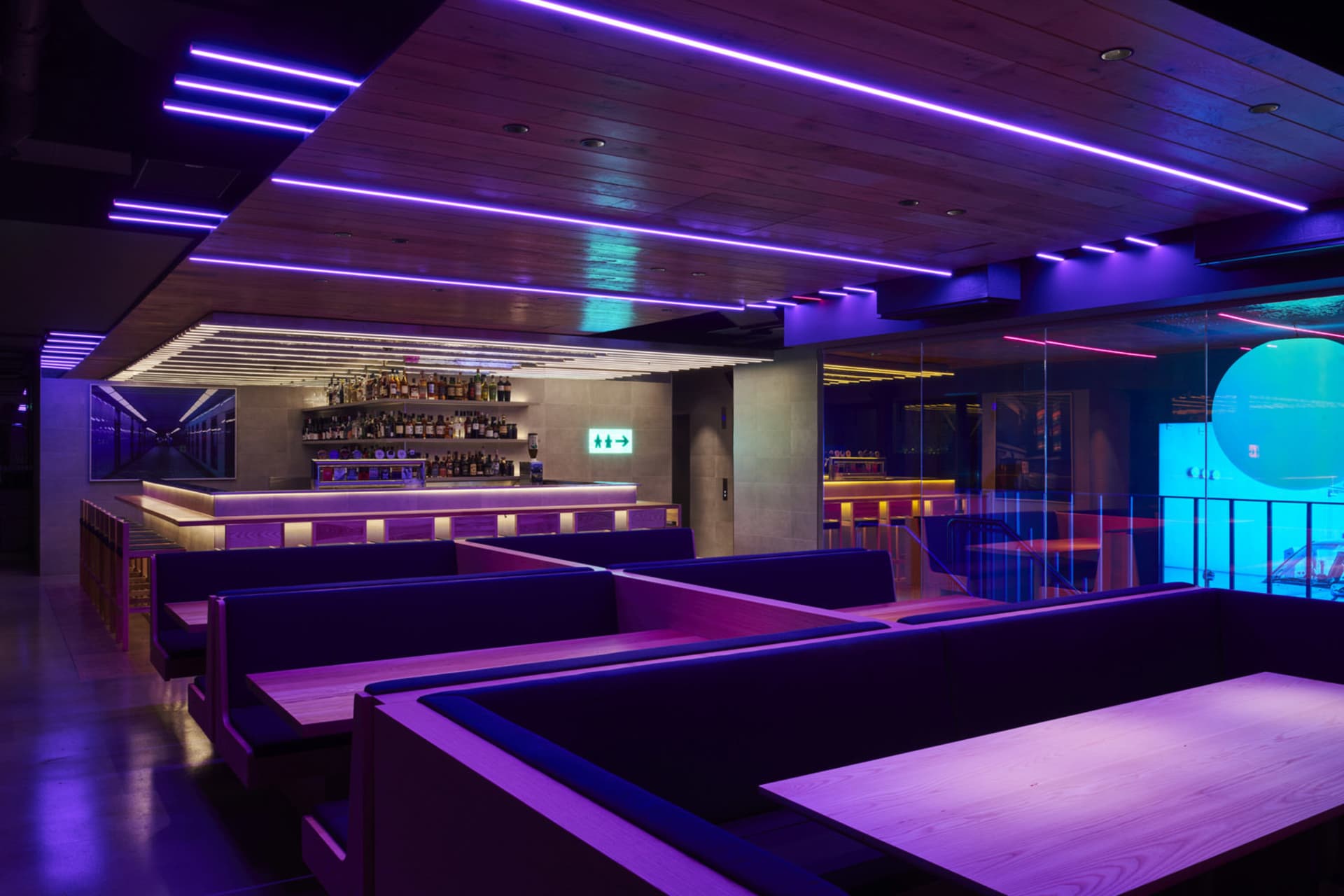 A modern restaurant featuring LED lighting and wooden benches