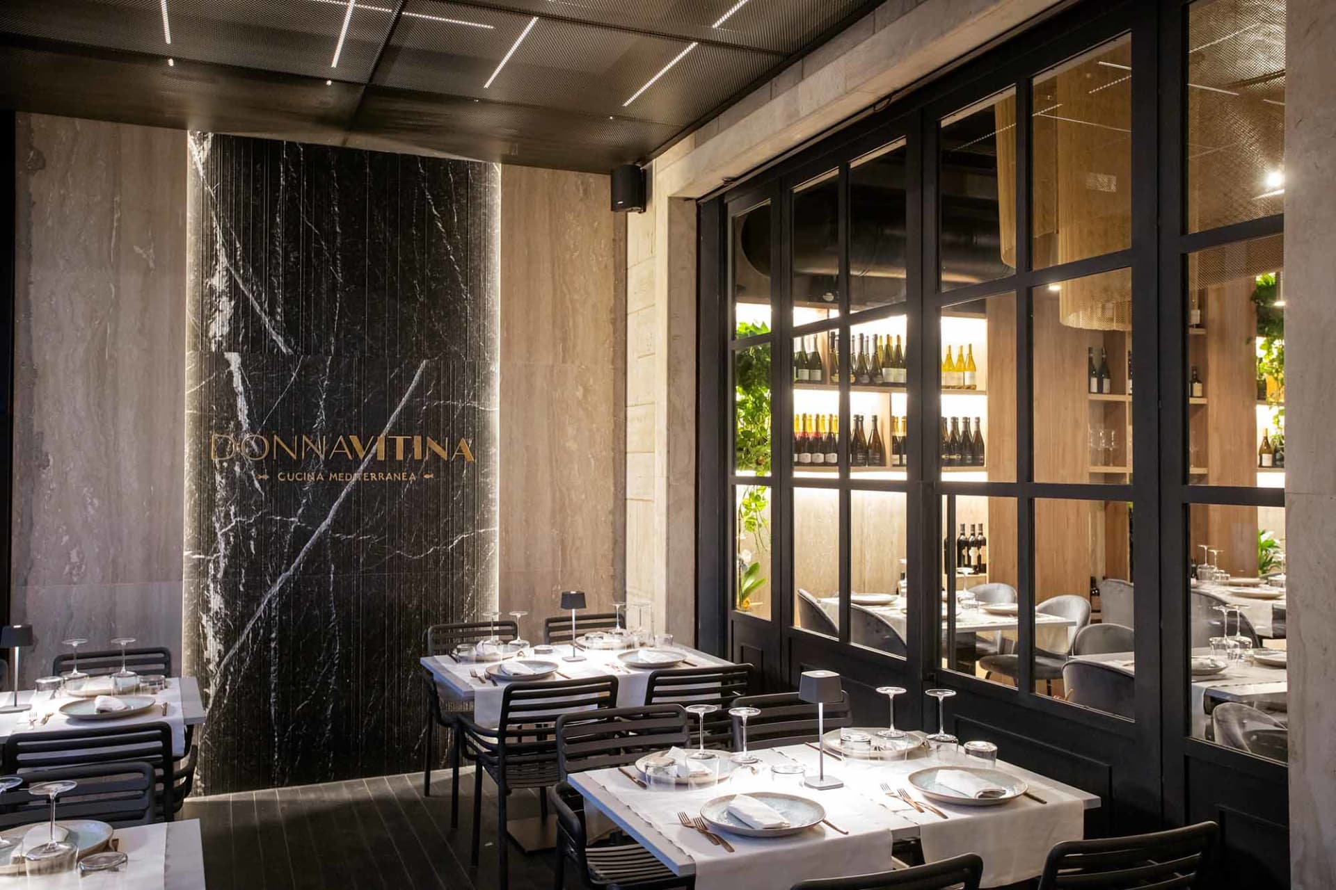 A modern restaurant interior featuring marble, glass, and concrete materials.