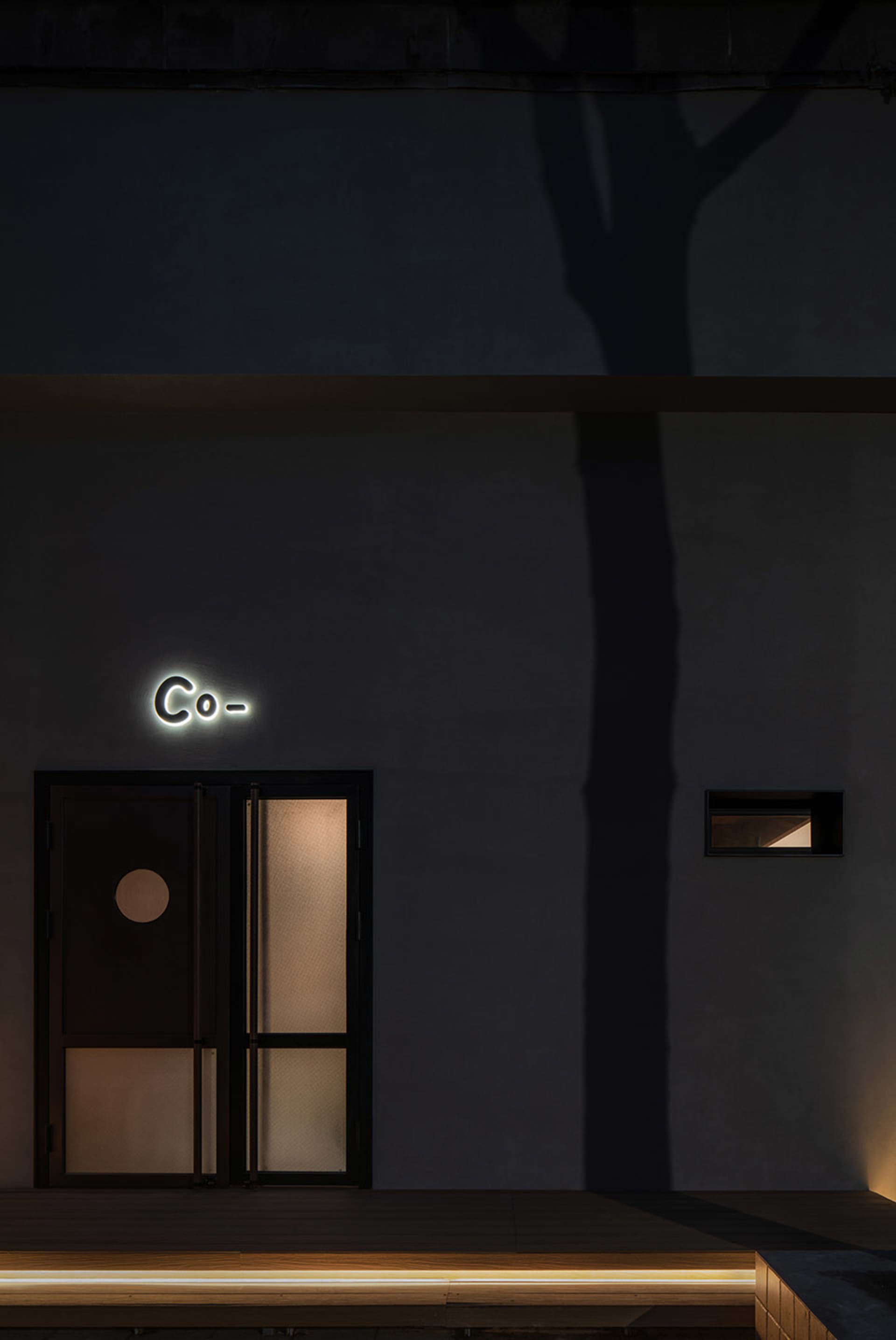 A modern retail storefront with glass frontage and a concrete base.