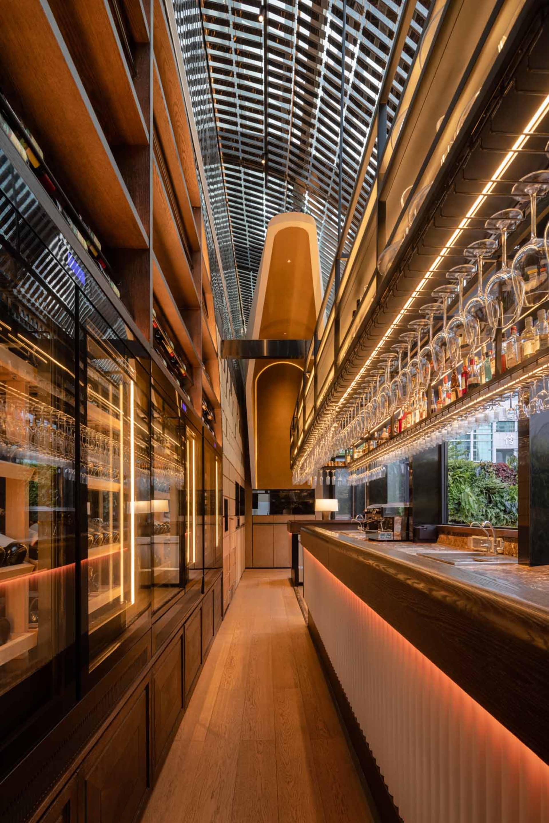 A modern bar with glass, wood, and metal elements.