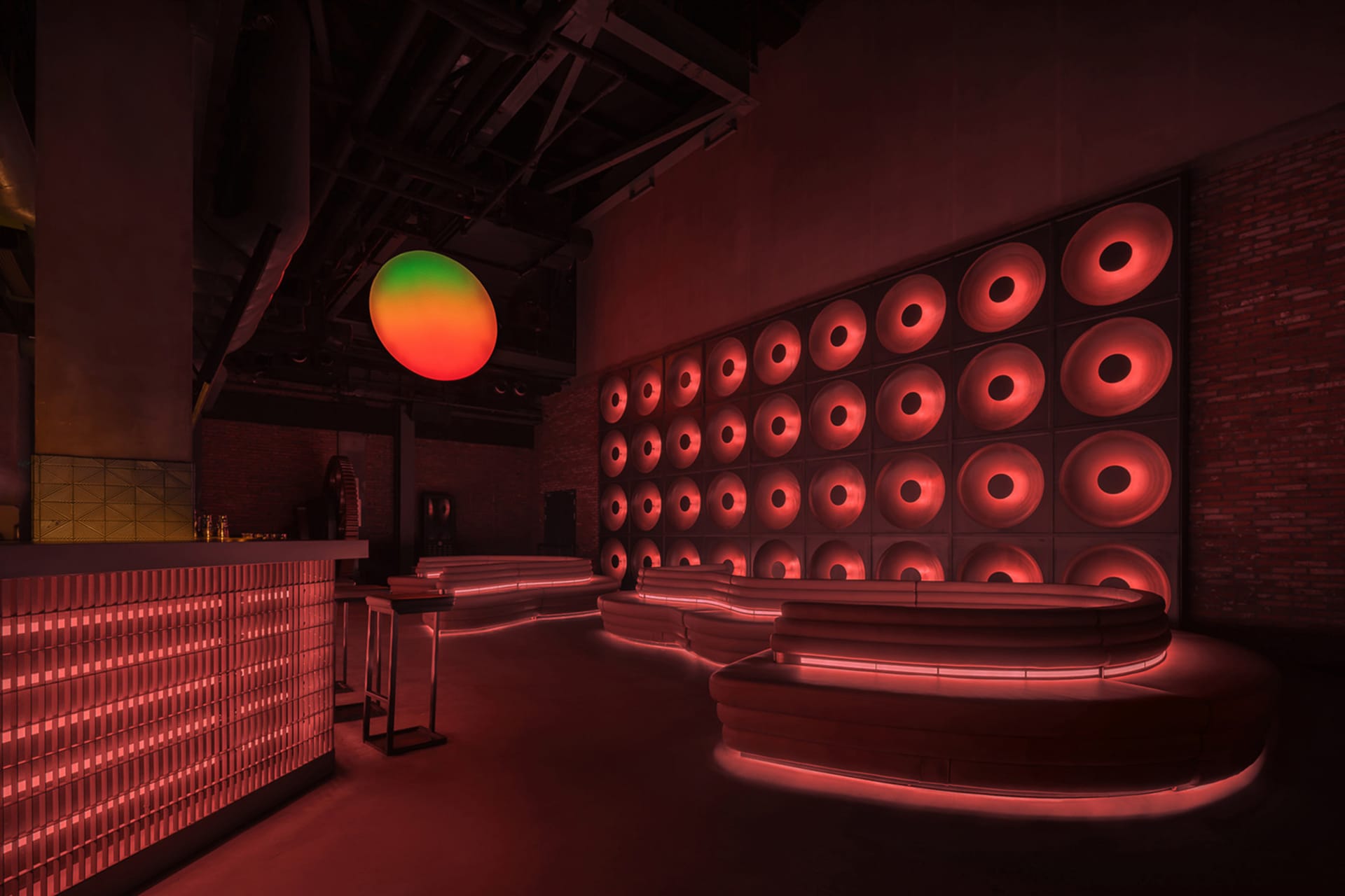 A modern industrial bar with concrete elements and illuminated metal features.