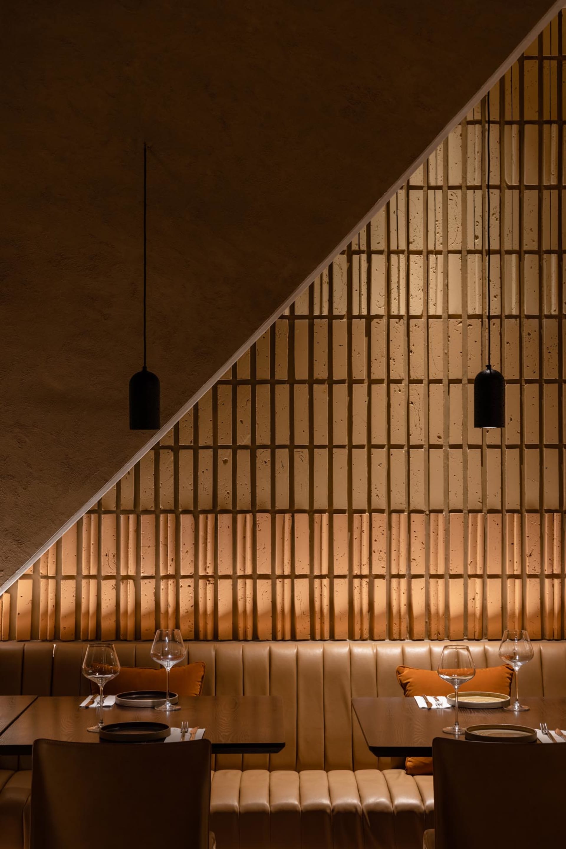 A modern restaurant interior with brown leather seating and a warm, cozy atmosphere.