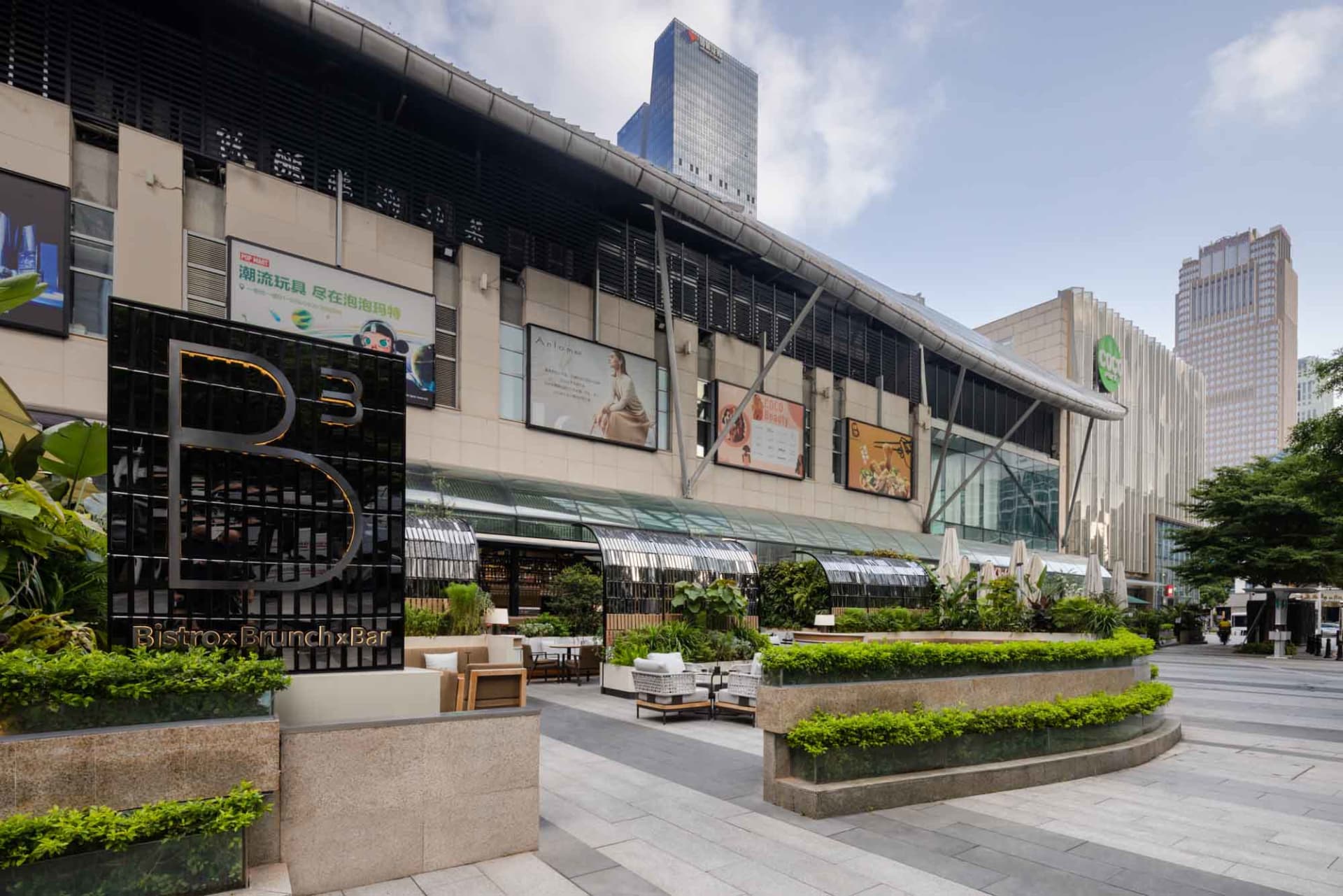 Modern retail storefront featuring glass, concrete, and metal materials.